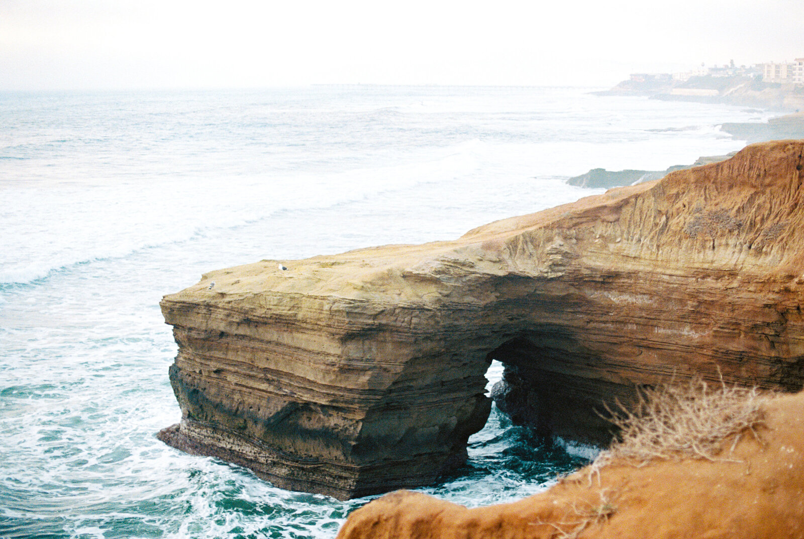 Colorful blue water hits against Sunset Cliff in San Diego California