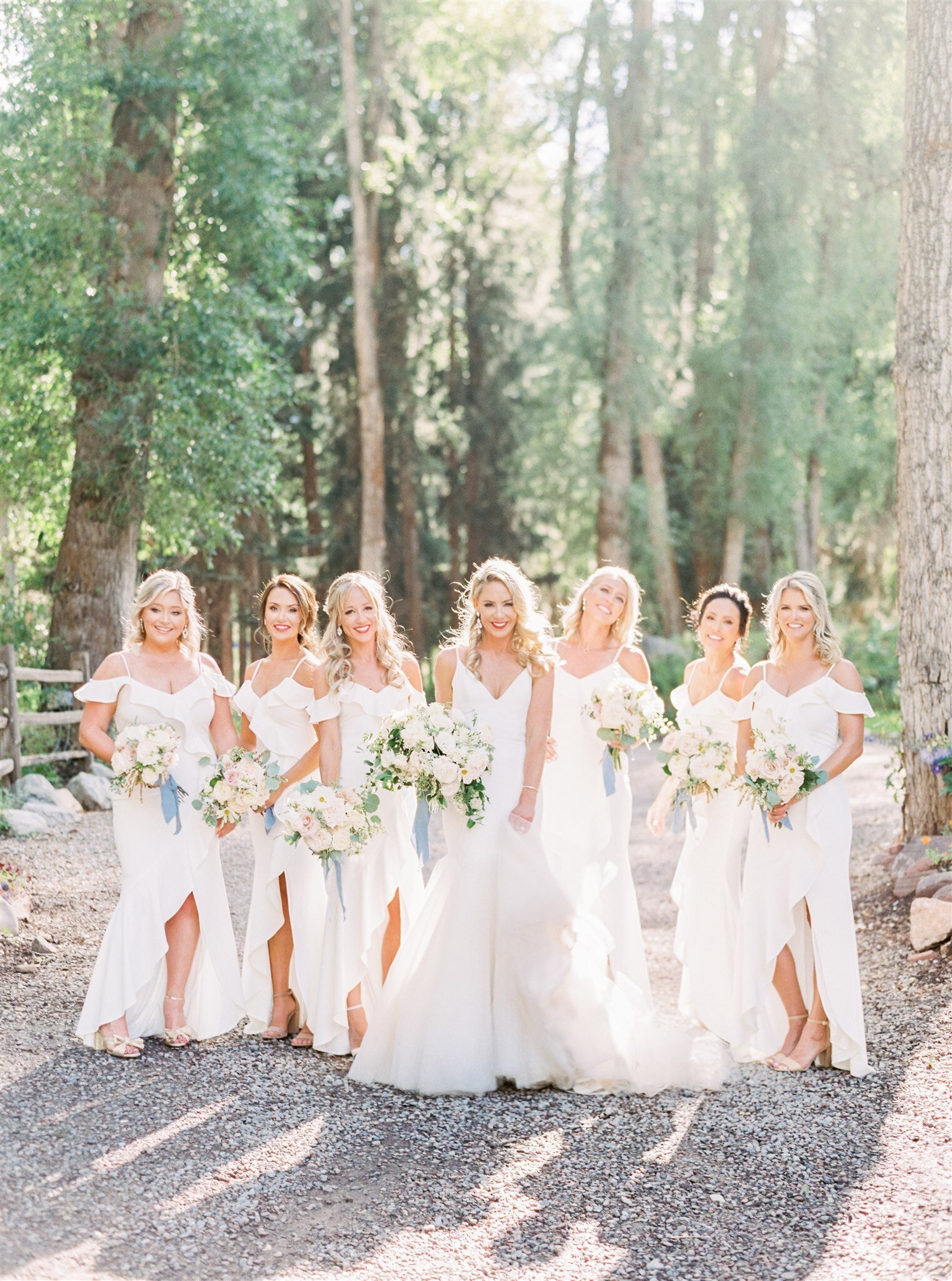 Happy bridal party in a treed outdoor setting
