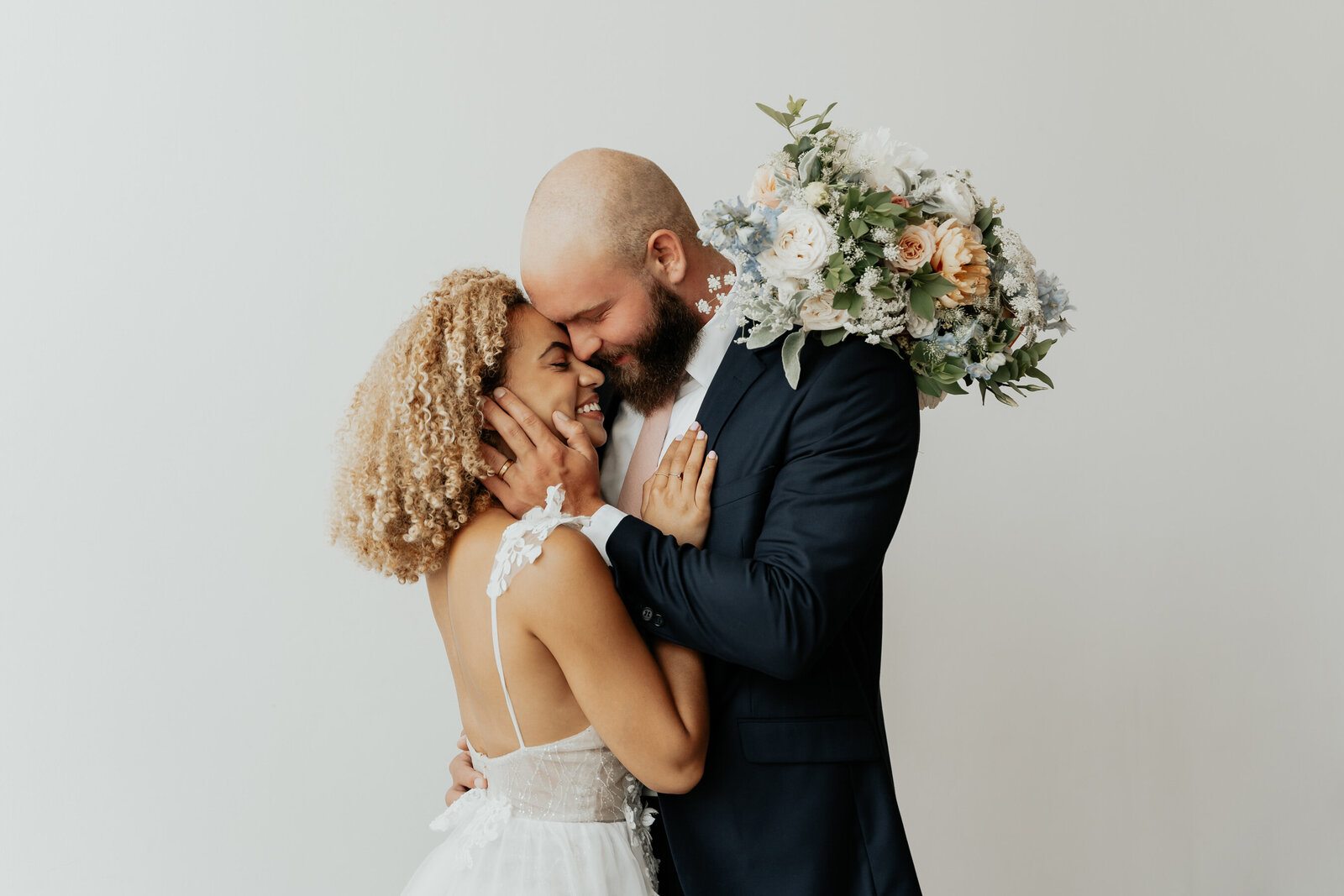 Utah wedding studio photos of a beautiful mixed couple with a mixed floral arrangement