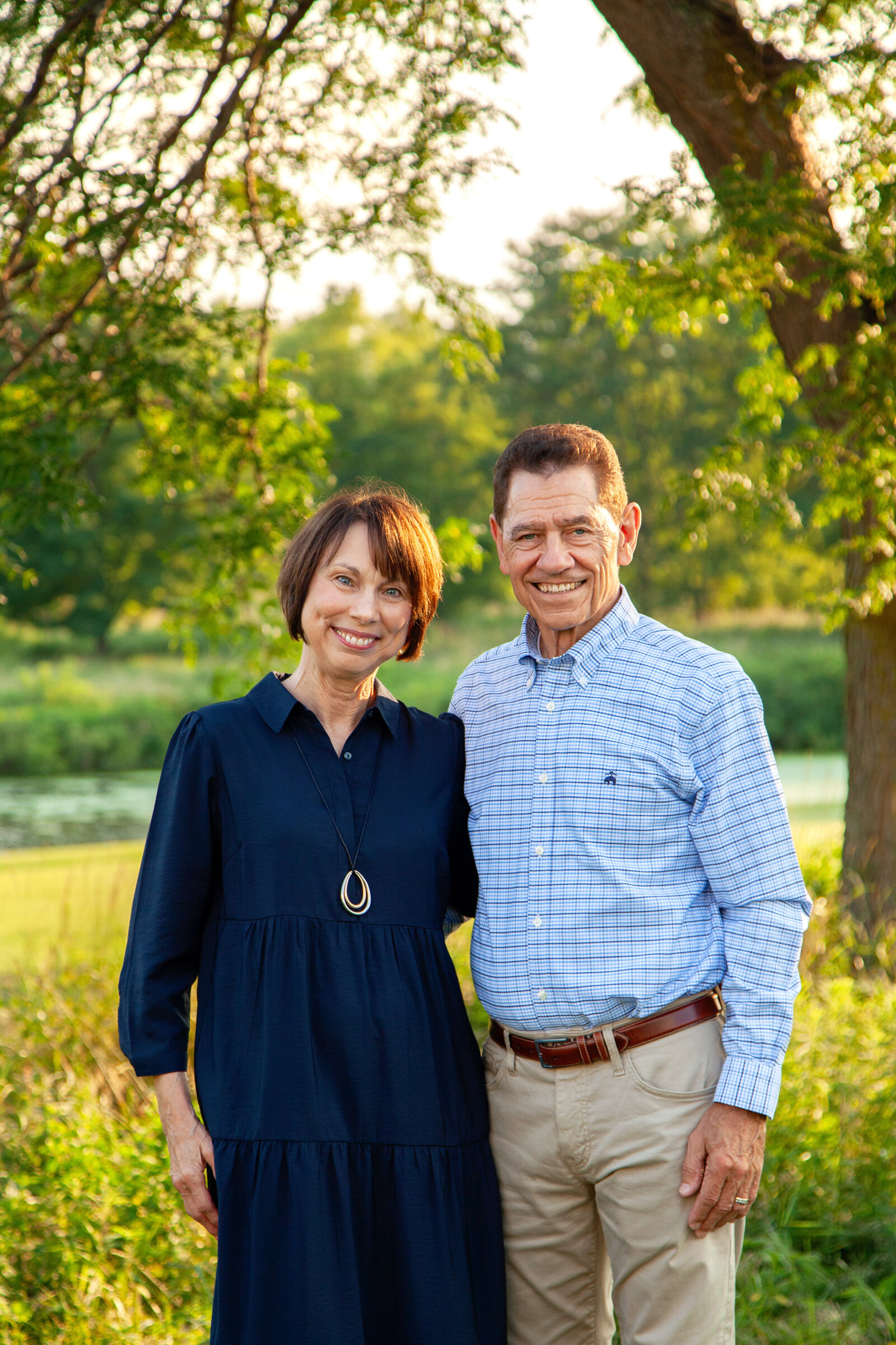 Older couple together, smiling, park background.