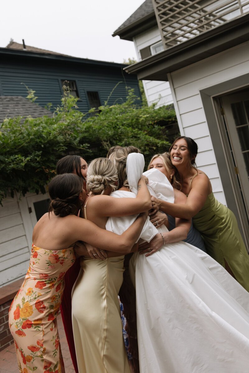bridesmaids hugging bride taken by idaho wedding photography