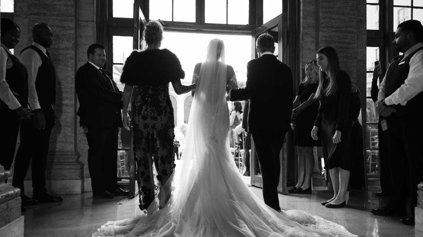 Bride walking down the aisle at The Breakers Palm Beach with her parents, photographed by Claudia Amalia, a wedding and lifestyle photographer in Miami and Florida Keys, South Florida.  Filename: bridal-portrait-the-breakers-palm-beach-claudia-amalia-photography.jpg Alt Text: Stunning br