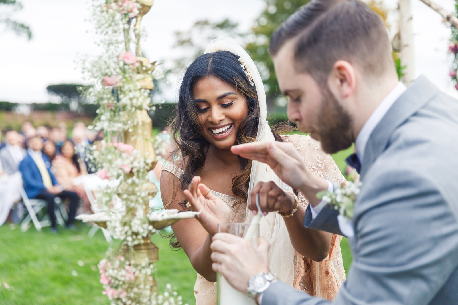 A wedding couple participating in the oil lamp ceremony of their wedding  Vermont Wedding