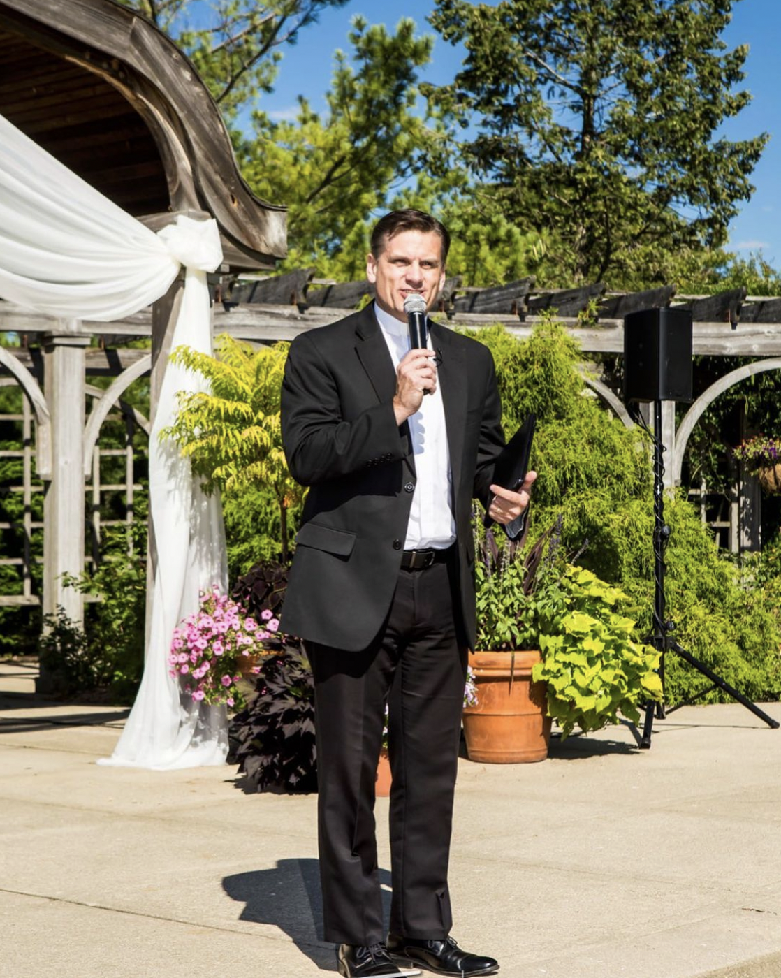 Wedding officiant stands at the front of wedding ceremony