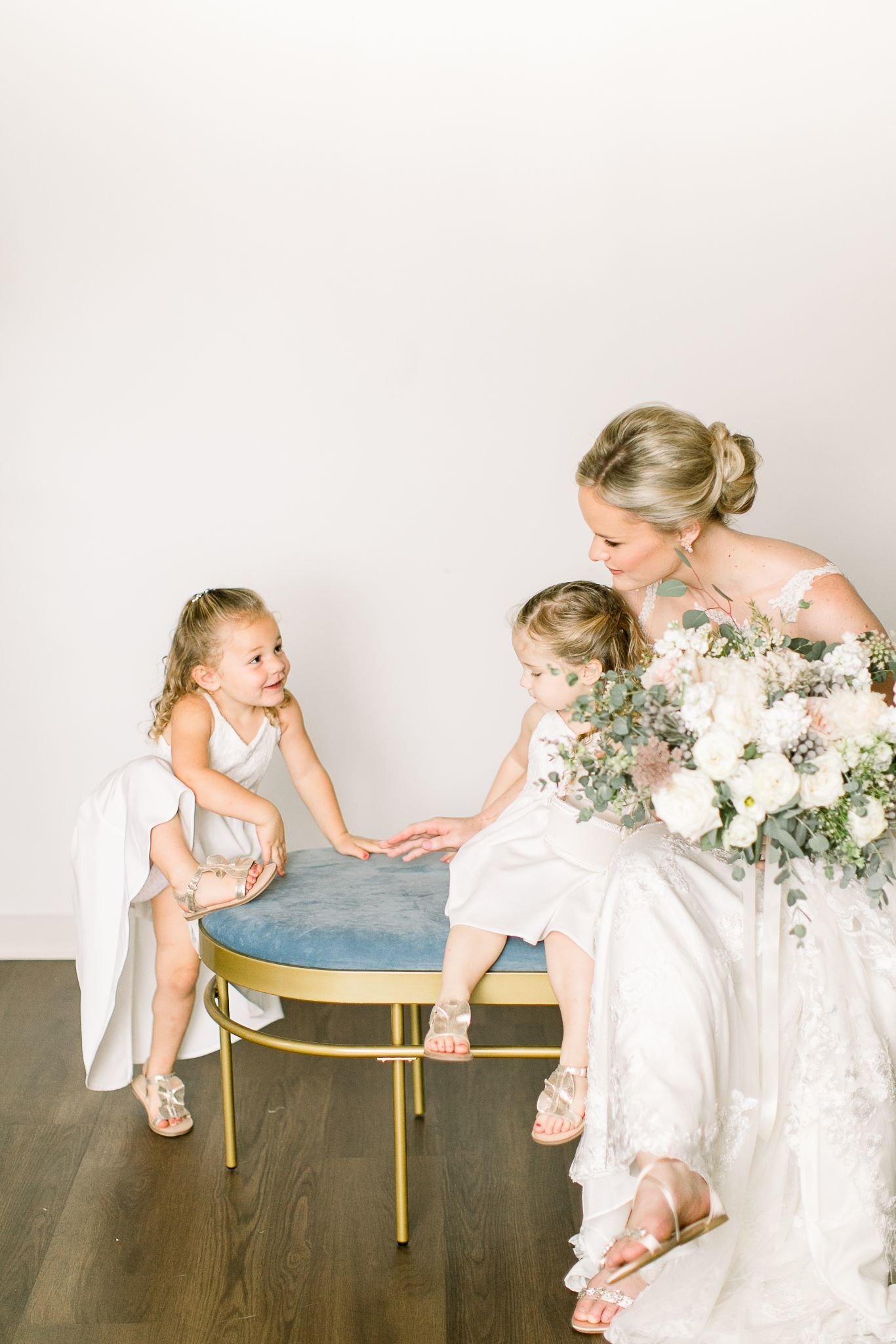 Candid wedding photograph of a bride and two flower girls