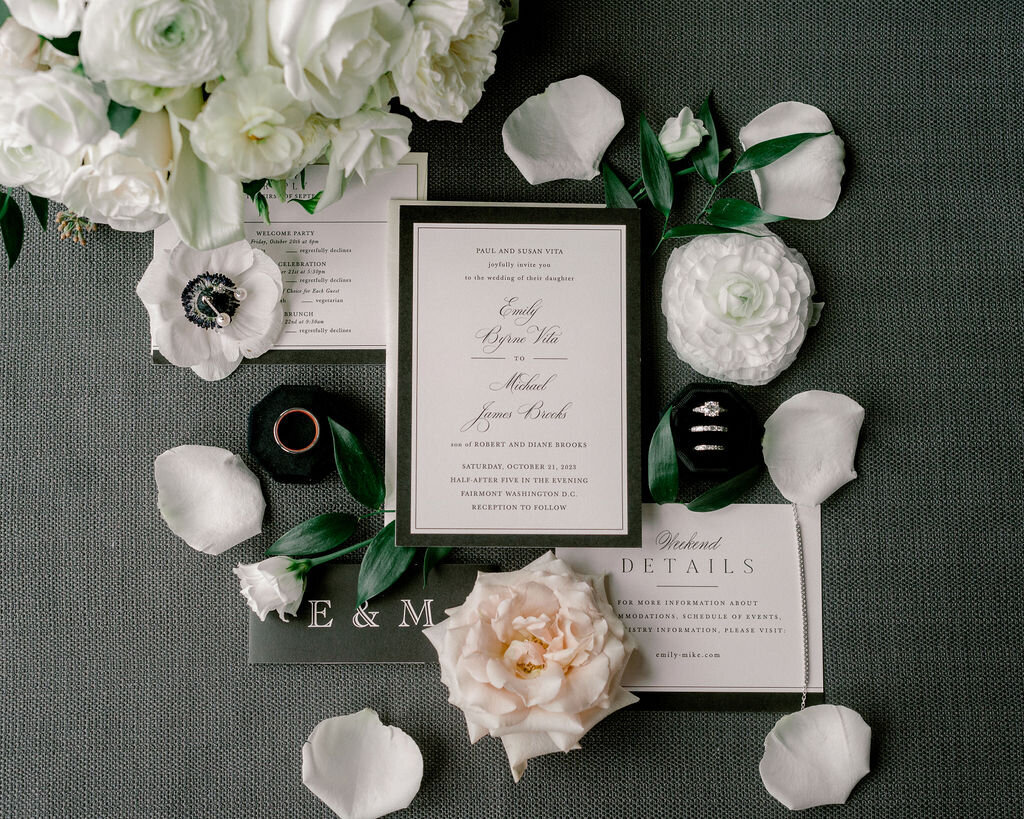 Wedding invitation and details on a black backdrop