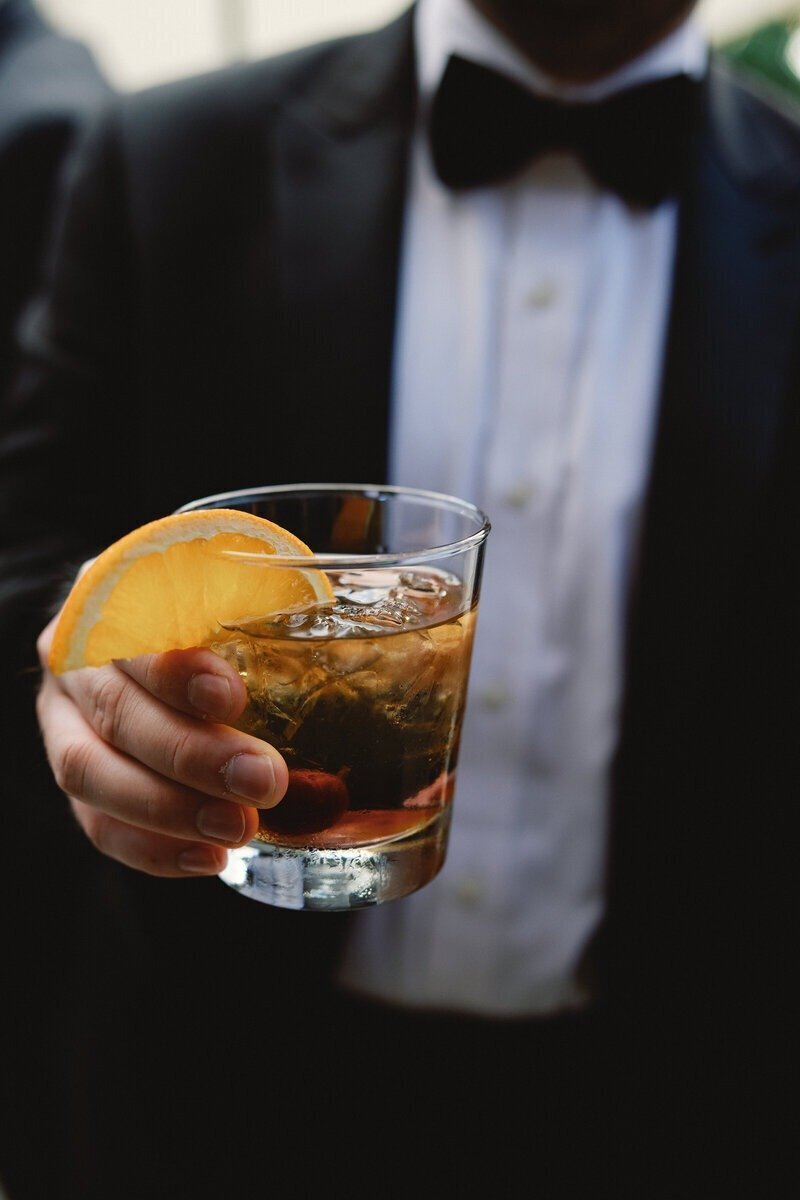 groom holding glass with drink at wedding in fort myers beach
