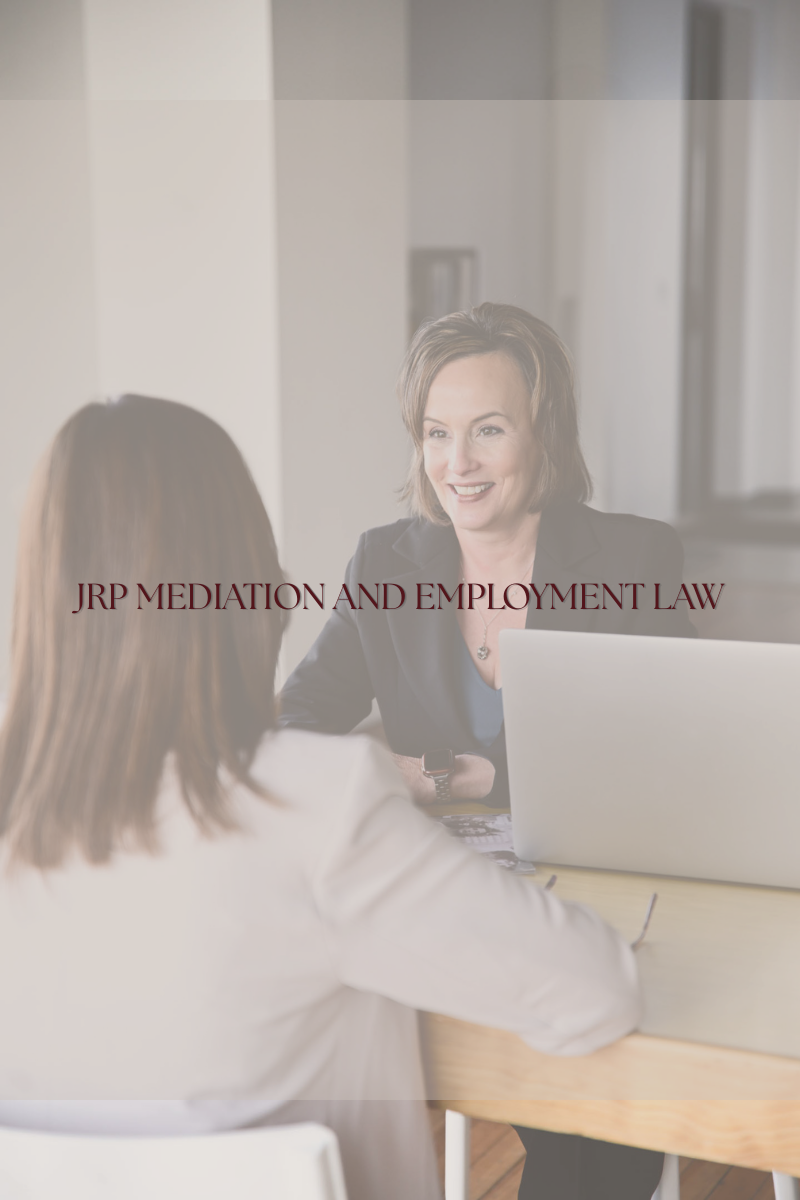 alt="Jennifer R Petersen smiling while meeting with a client in her office with a laptop, JRP Mediation and Employment Law Firm"
