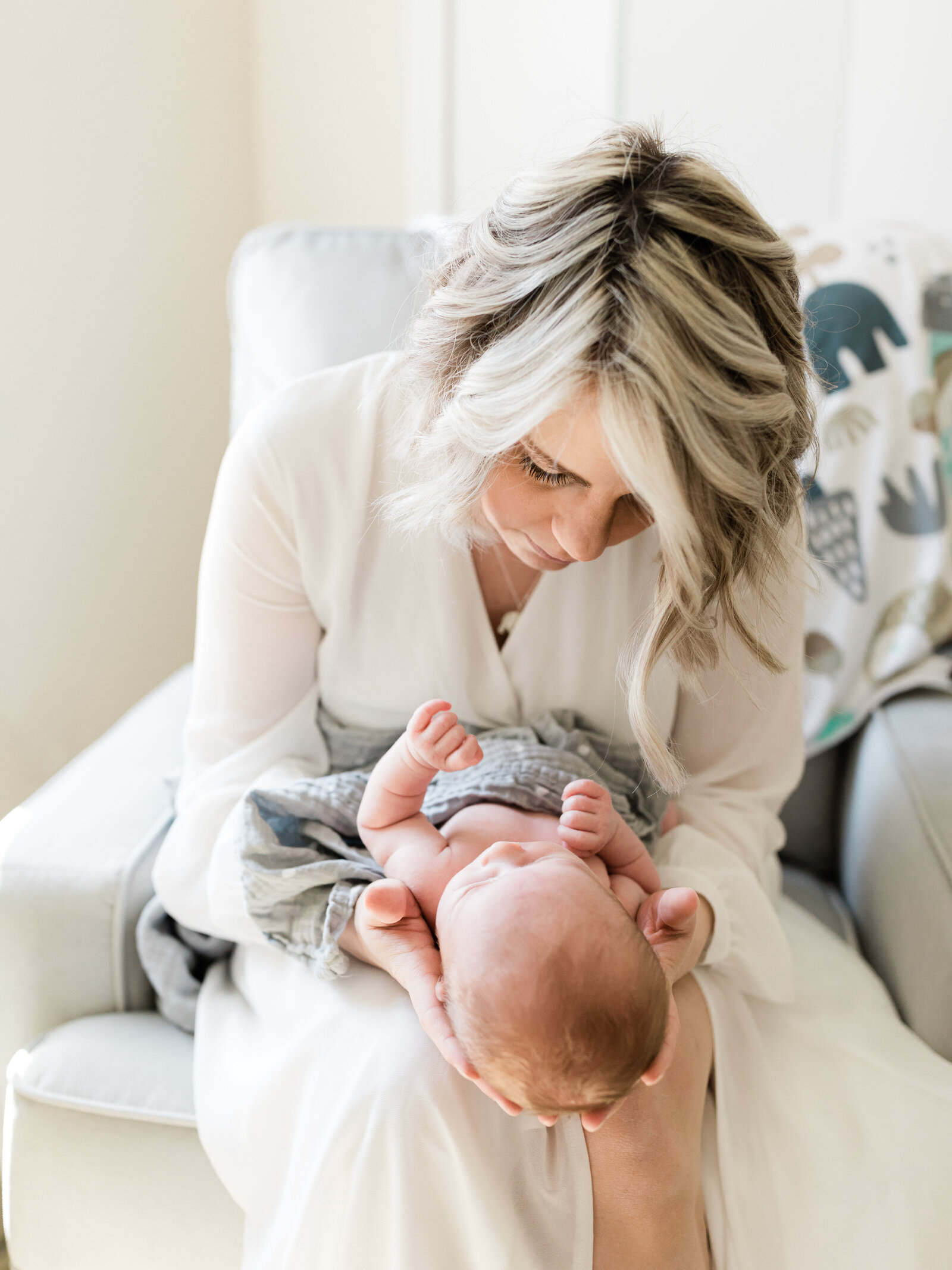 mom holding newborn baby girl for in home photoshoot