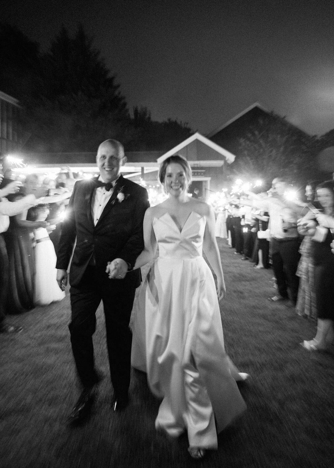 Black and white of bride and groom exiting wedding reception at Glen Ella