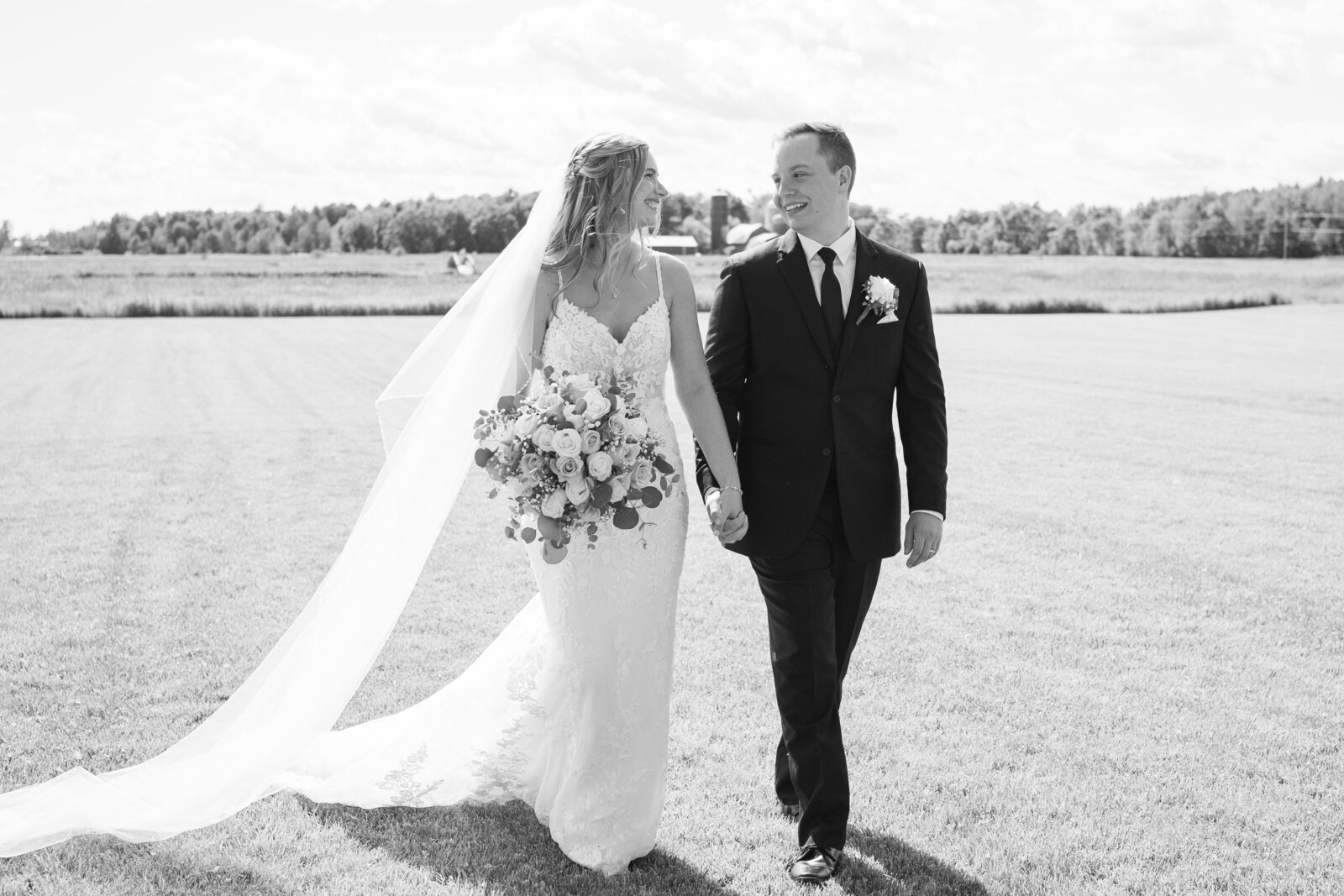 Married couple walks to their reception, in black and white