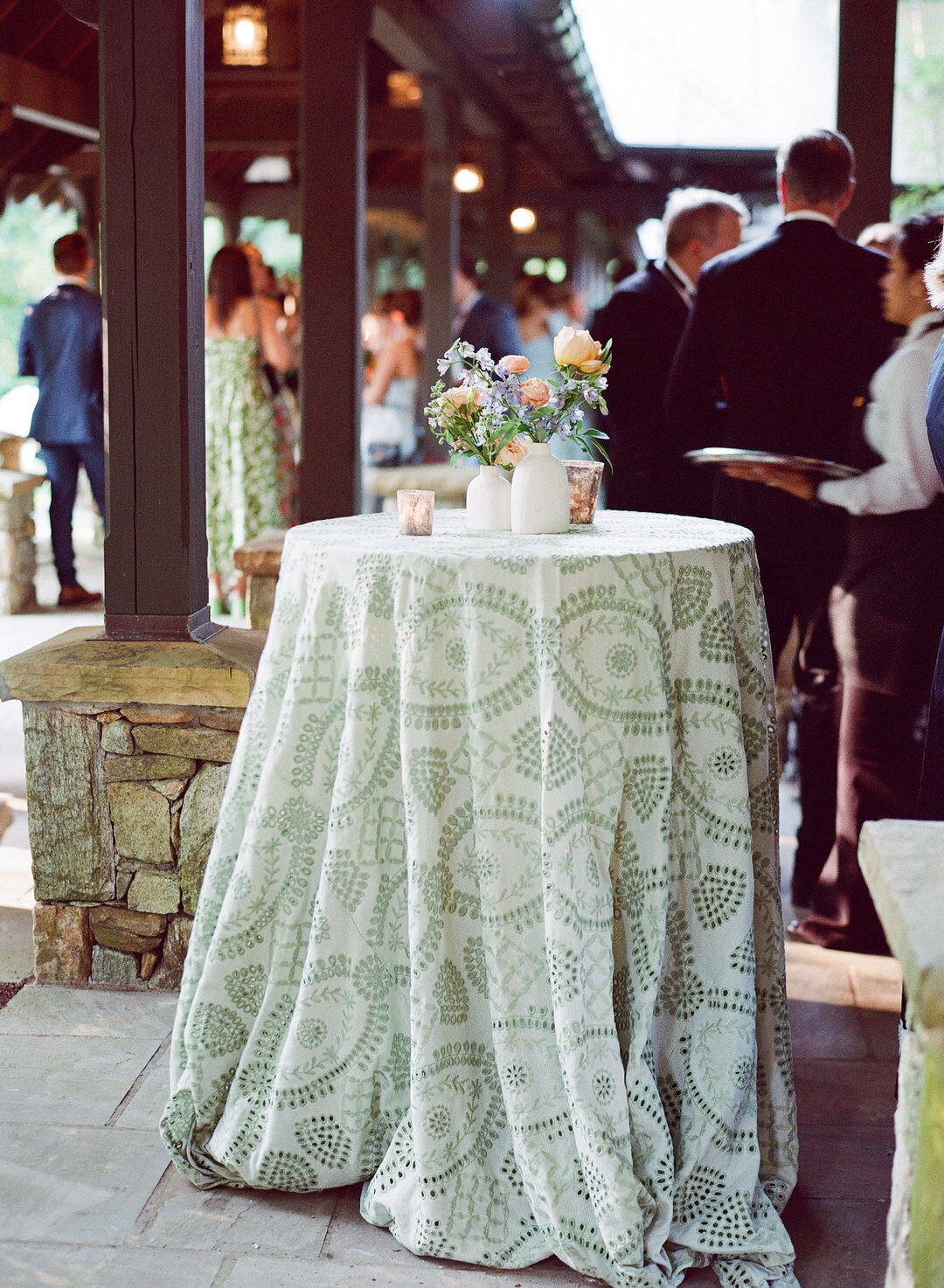 Cocktail hour table with flowers and pretty green table cloth