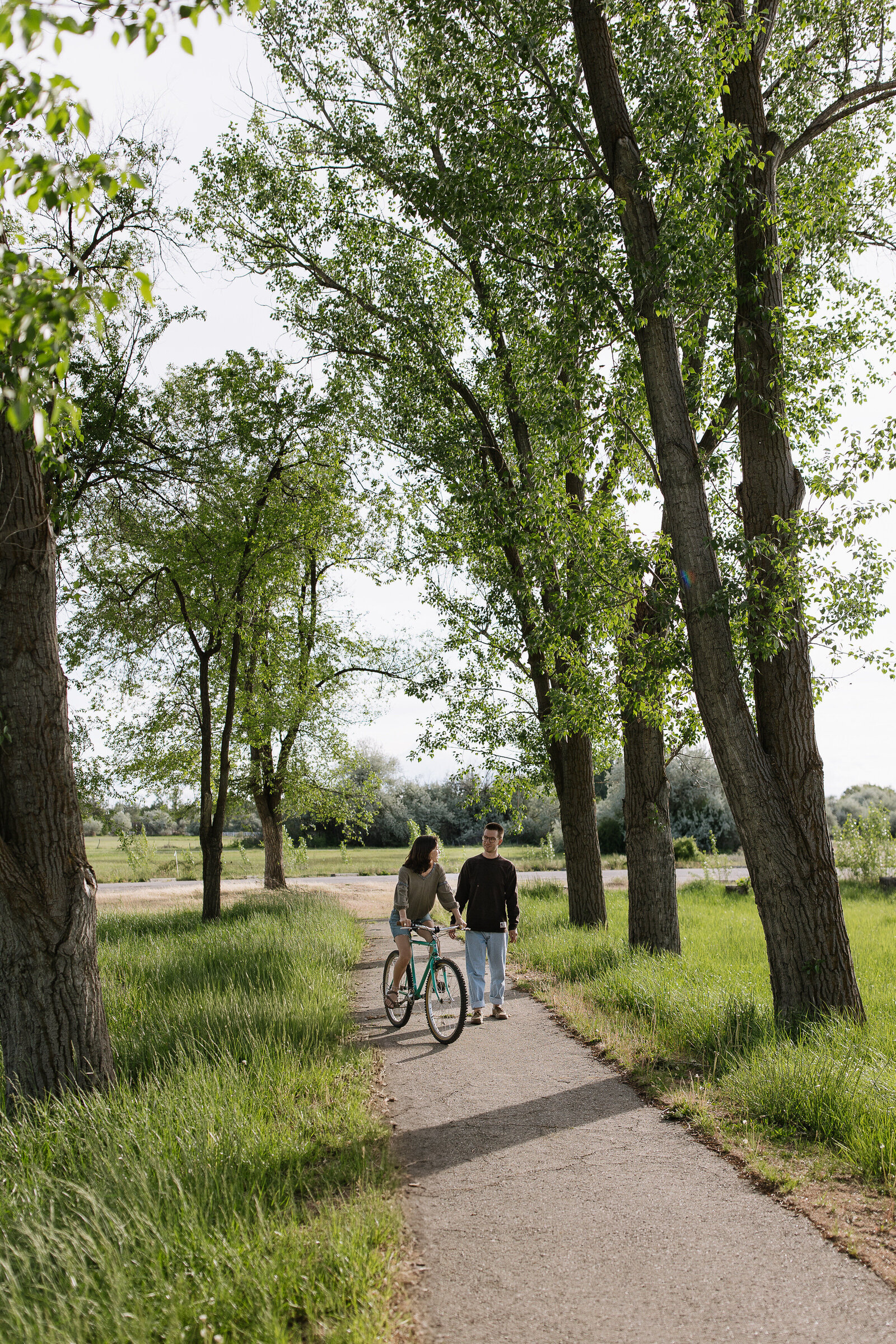 Bicycle couple session at sunset captured in candid and joyful moment