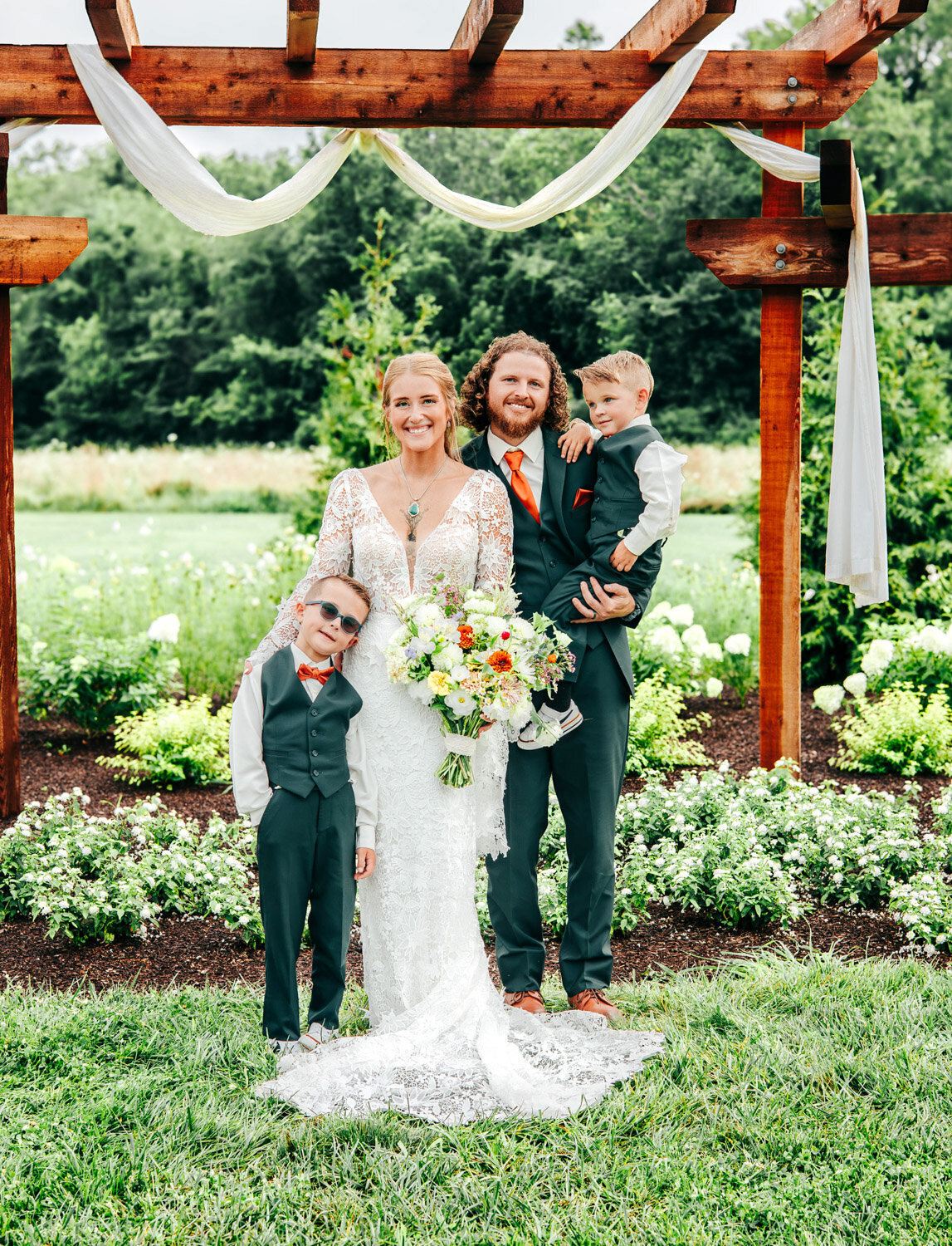 Bride and groom photo at the wedding altar with their two kids