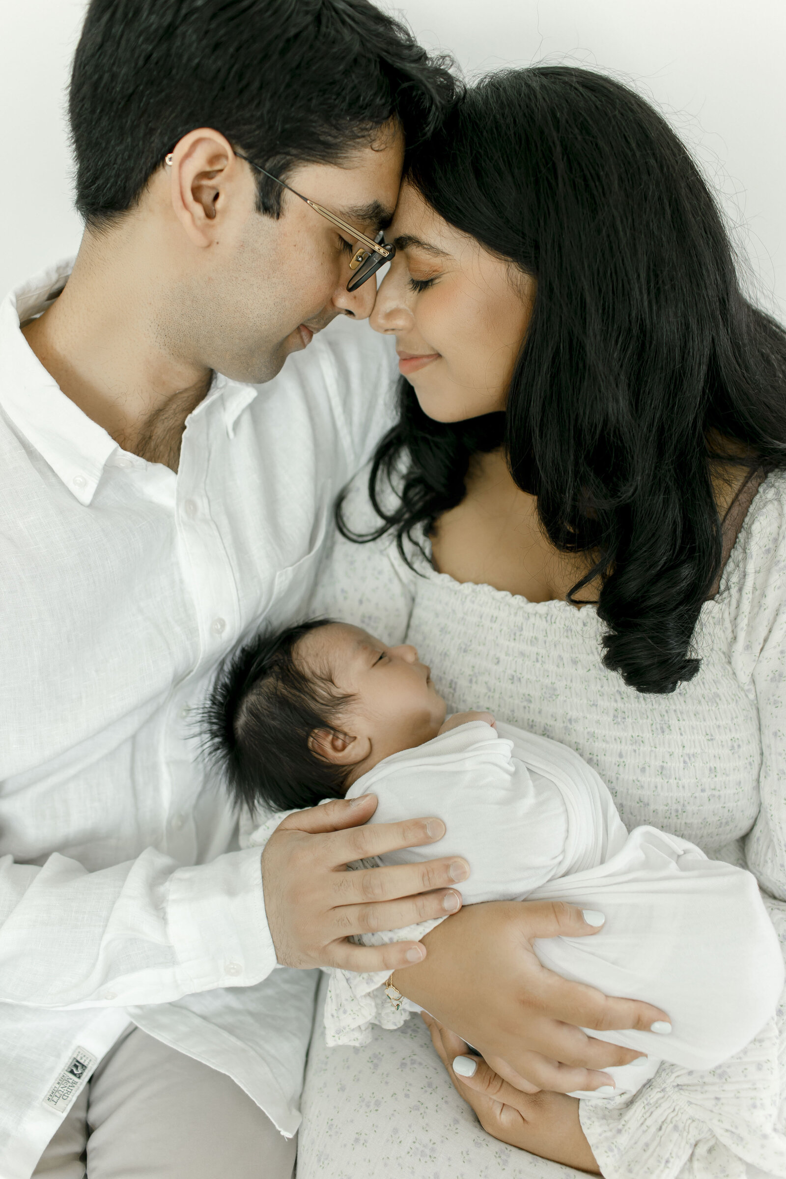 mom and dad embracing holding newborn taken by nj newborn photographer