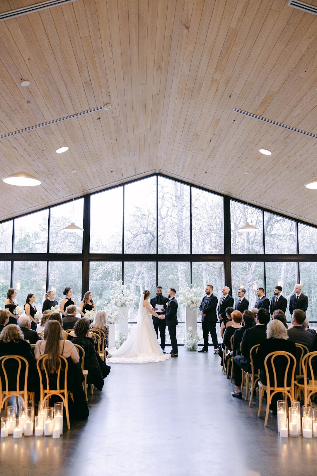 Indoor wedding ceremony in The Grand Lady's reception hall, with floor-to-ceiling windows