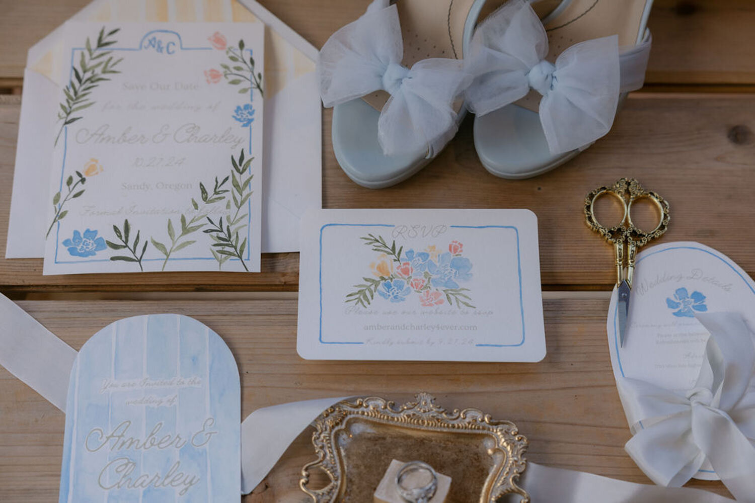 Flat lay of wedding stationery, shoes, and vintage scissors