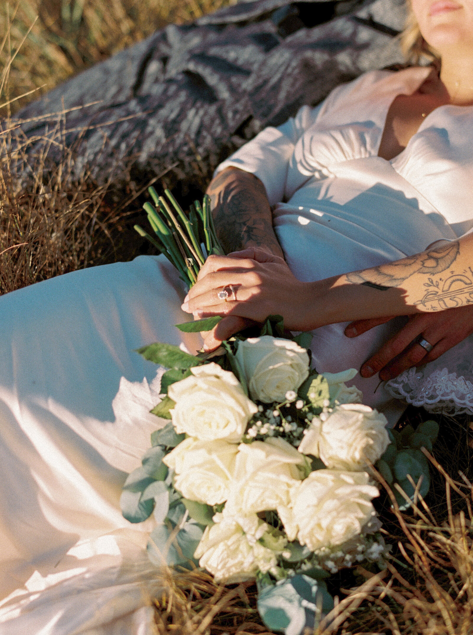 Bride with emerald cut ring holding white long stemmed roses photographed by Jackson Hole luxury film wedding photographer Magnolia Tree Photo Company