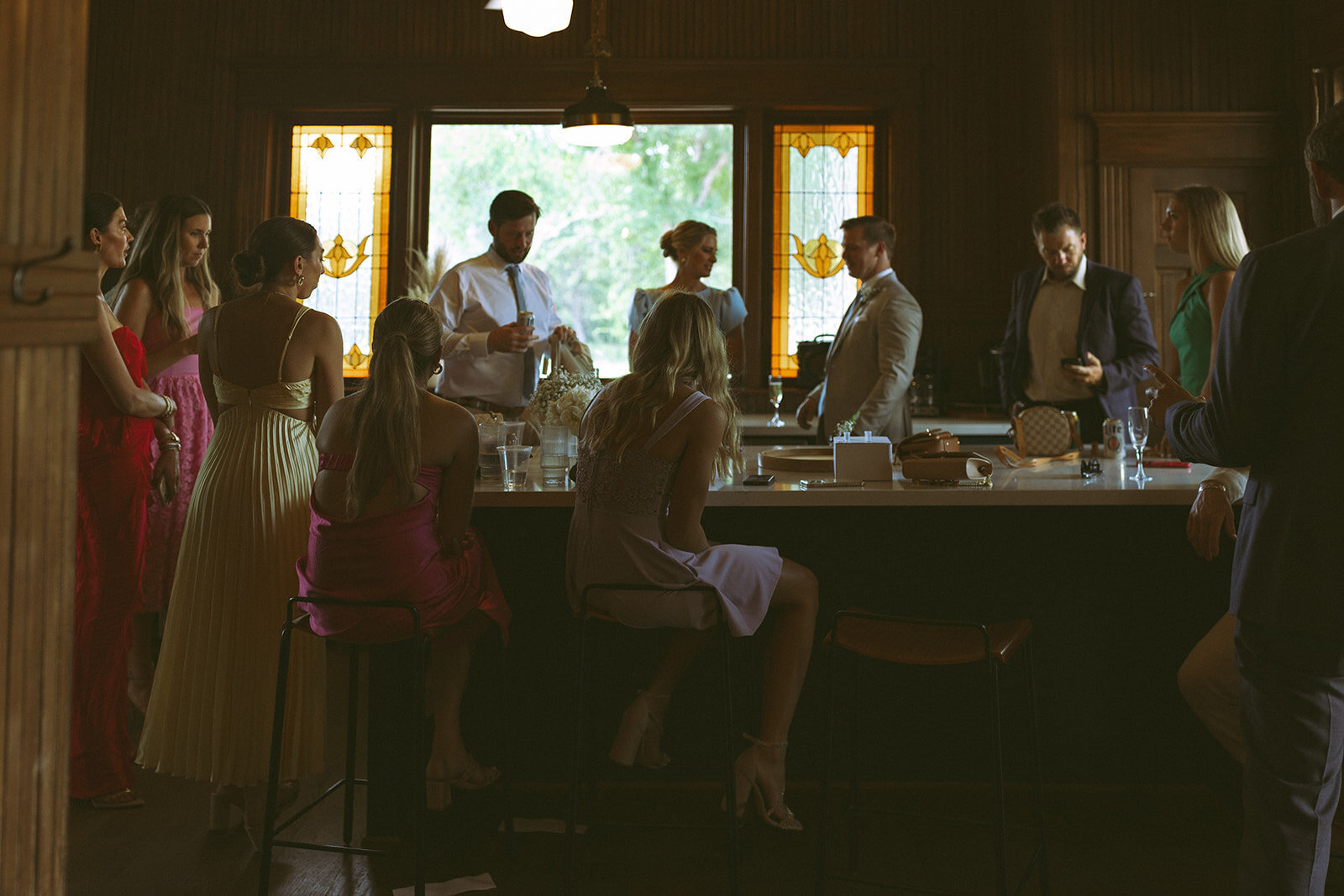 Wedding party gathered in the mansion kitchen under stained glass windows