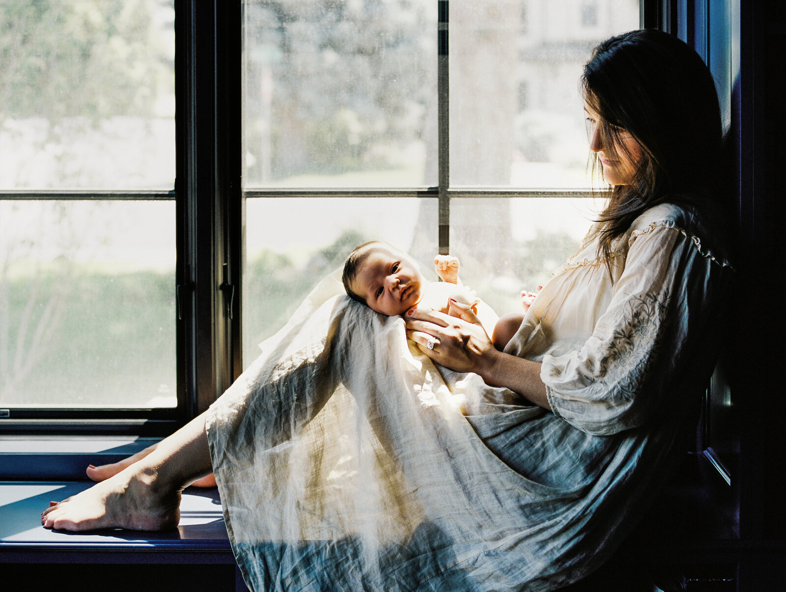 baby looks at camera while mom looks at baby