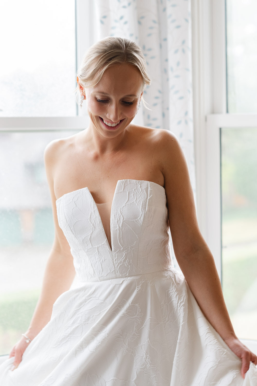 bride swings dress in window