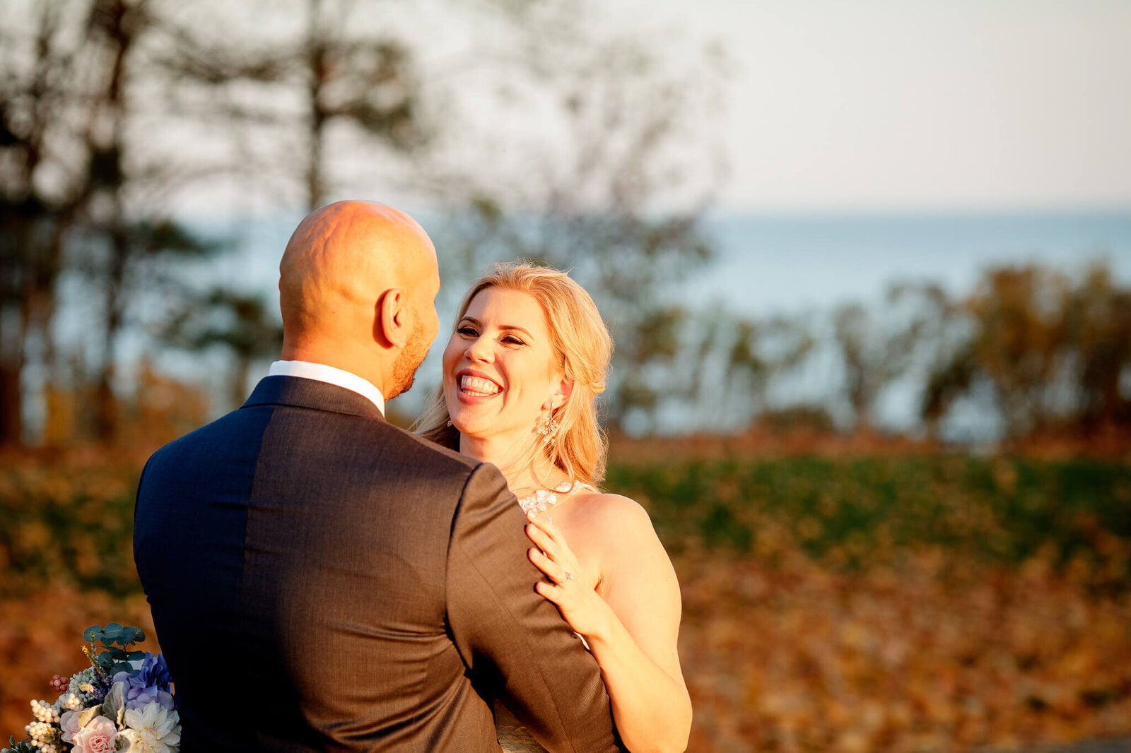 bride and groom smile at each other during outdoor portraits