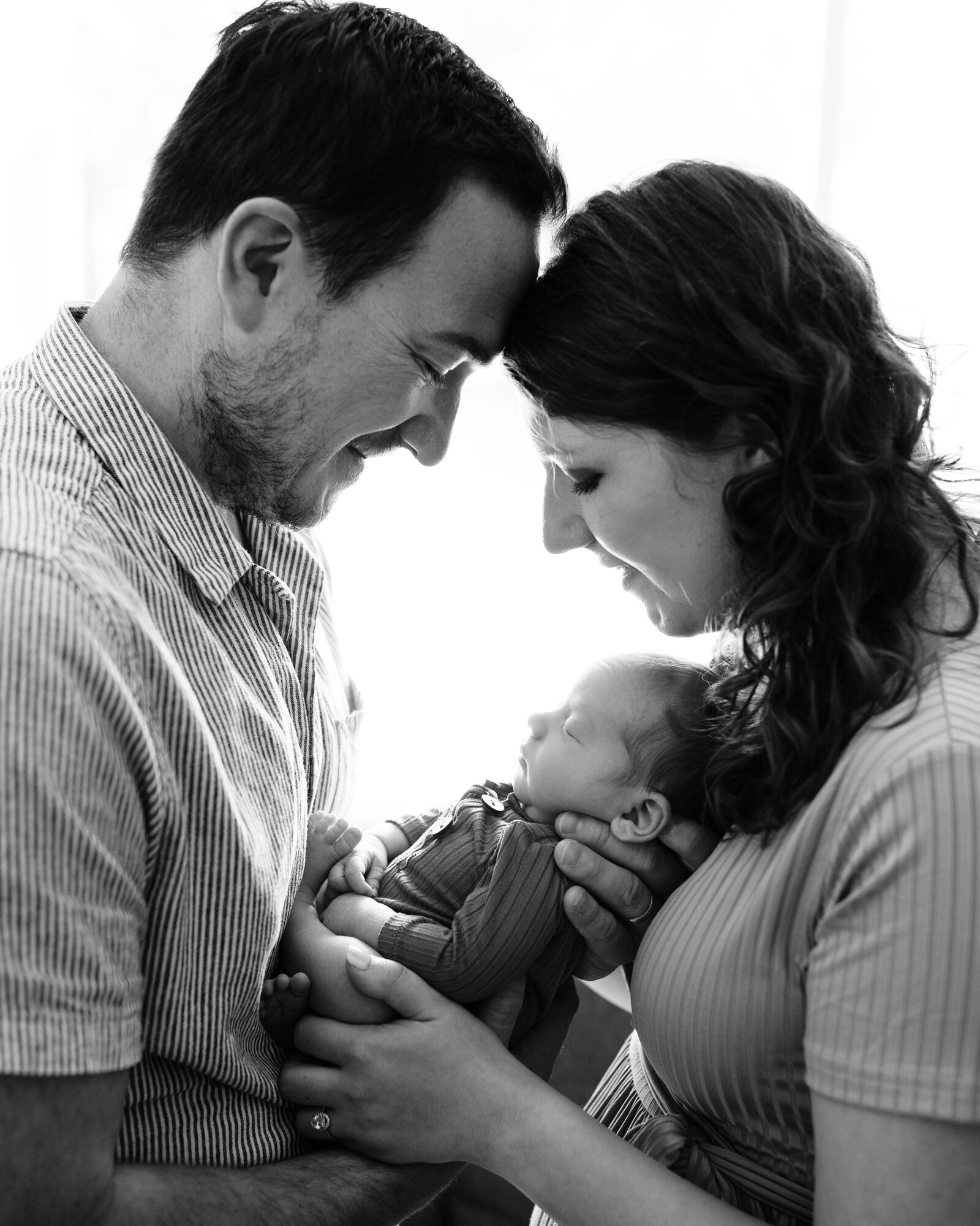 mom and dad holding newborn baby boy 