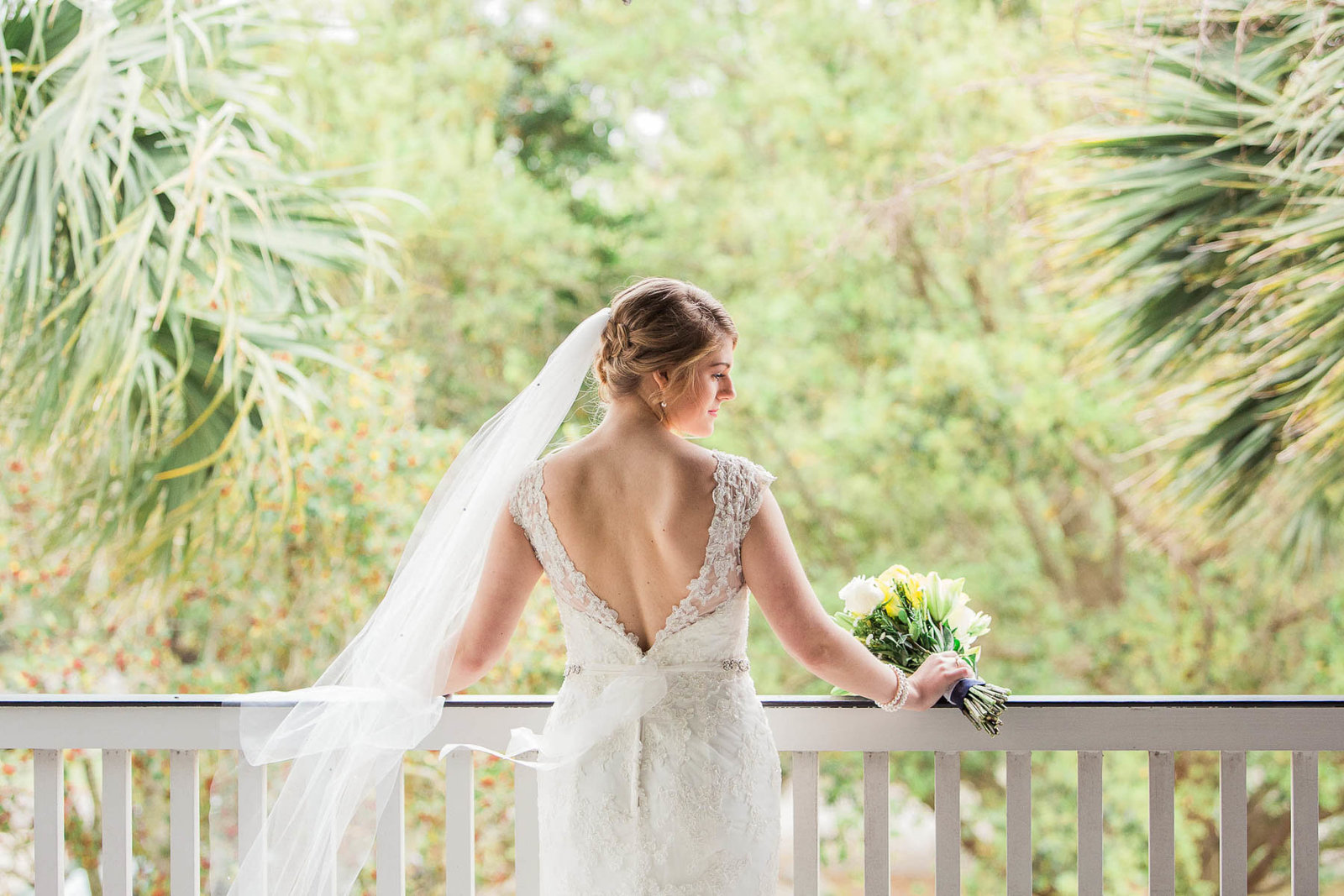 Bride leans on railing with veil blowing, Alhambra Hall, Charleston, South Carolina