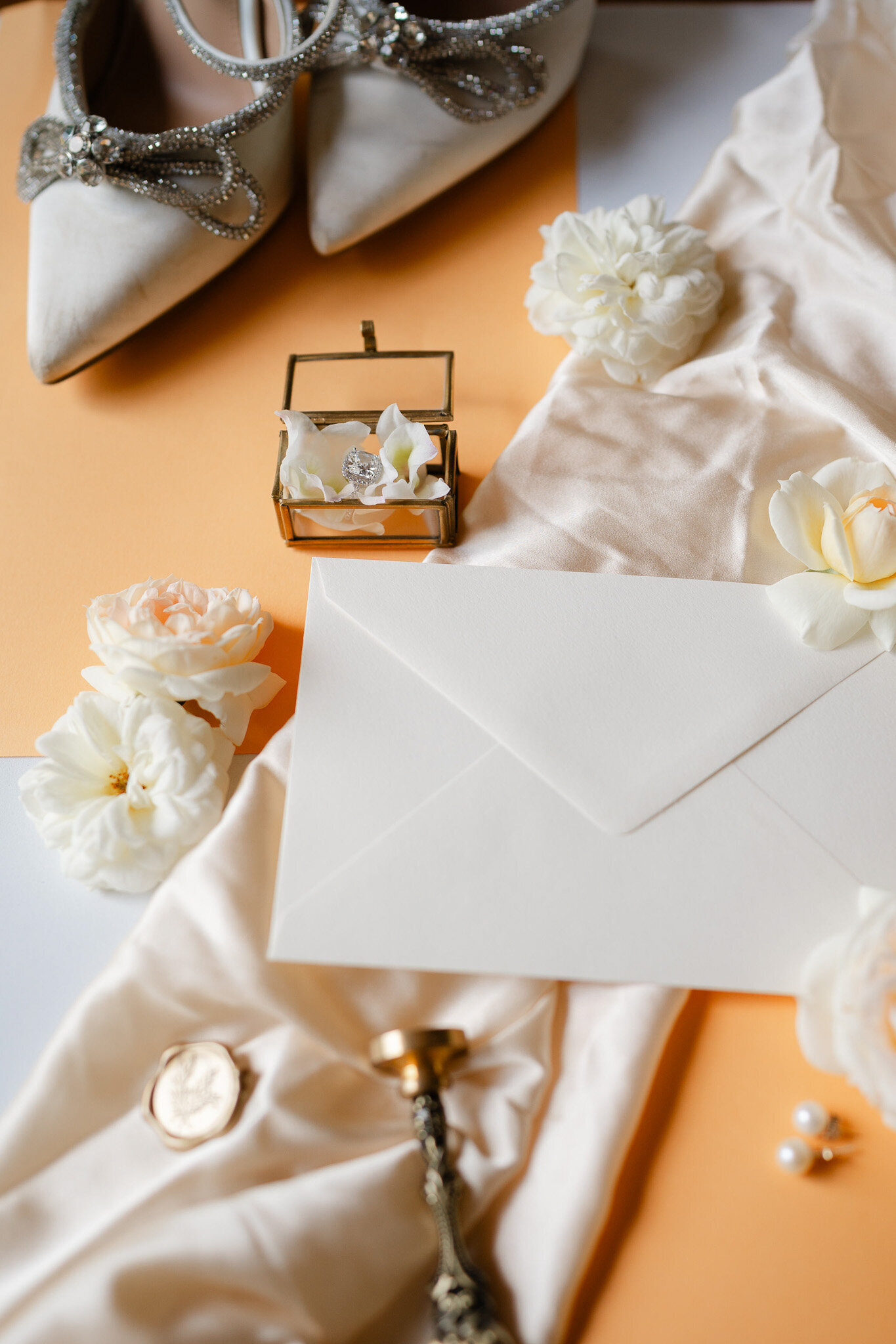 Dusty peach bridal flat lay, wedding shoes, flowers, invitations 