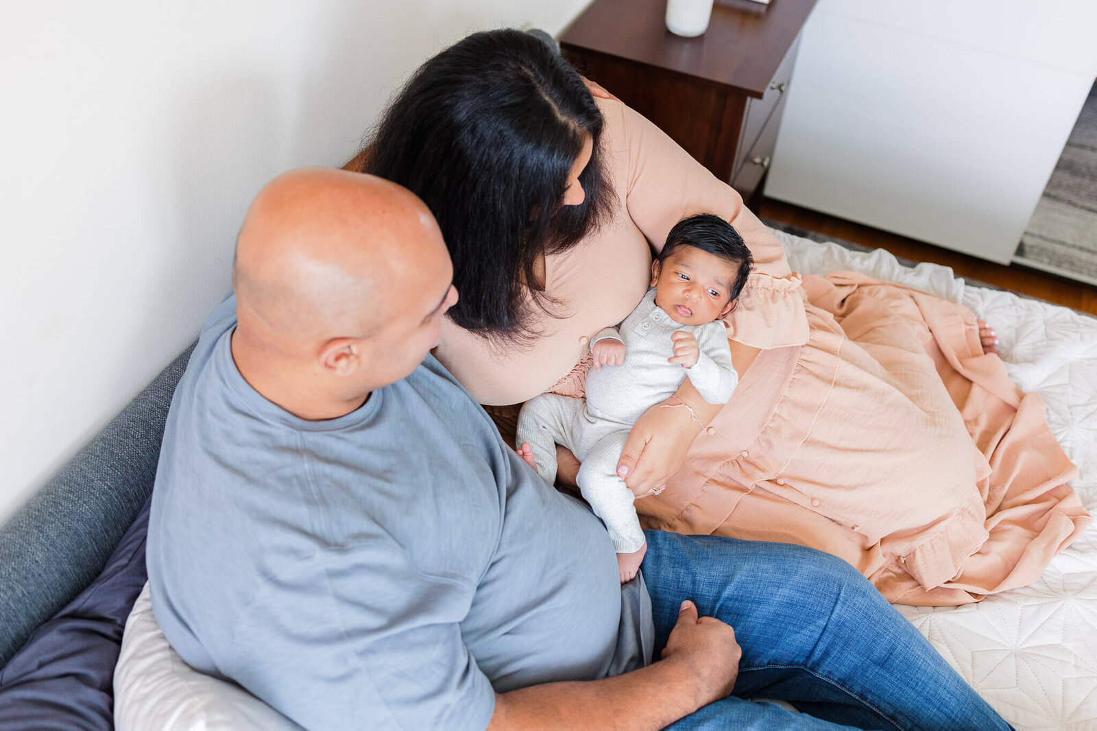A newborn boy being held by his mom and dad.