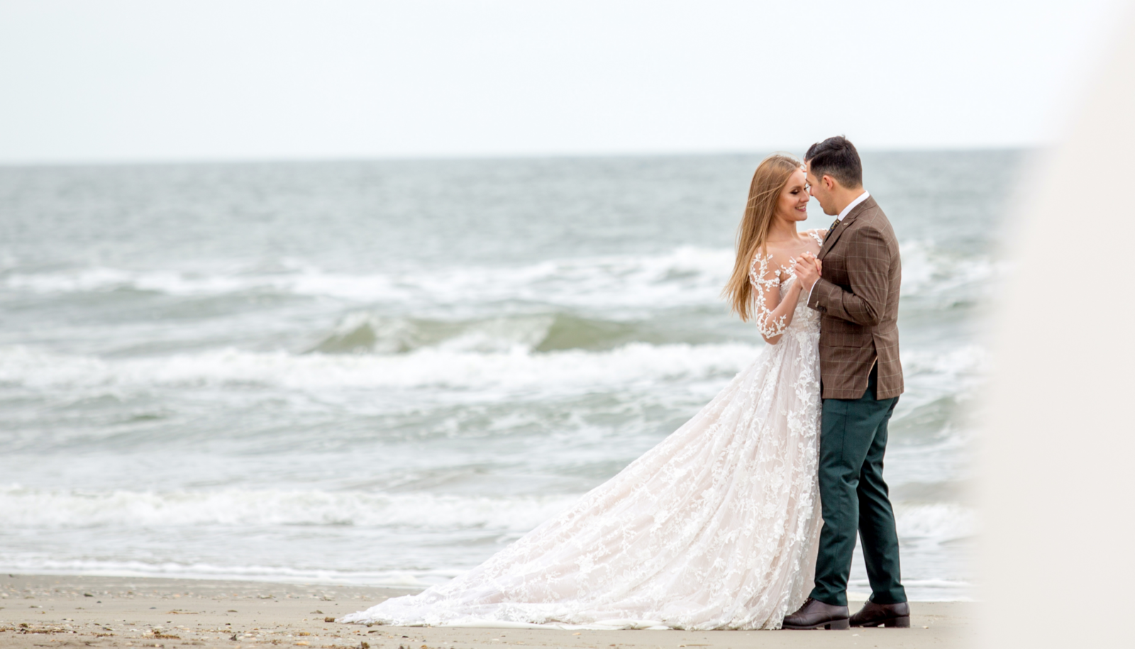 Bride and Groom slow dancing on the beach by the ocean.