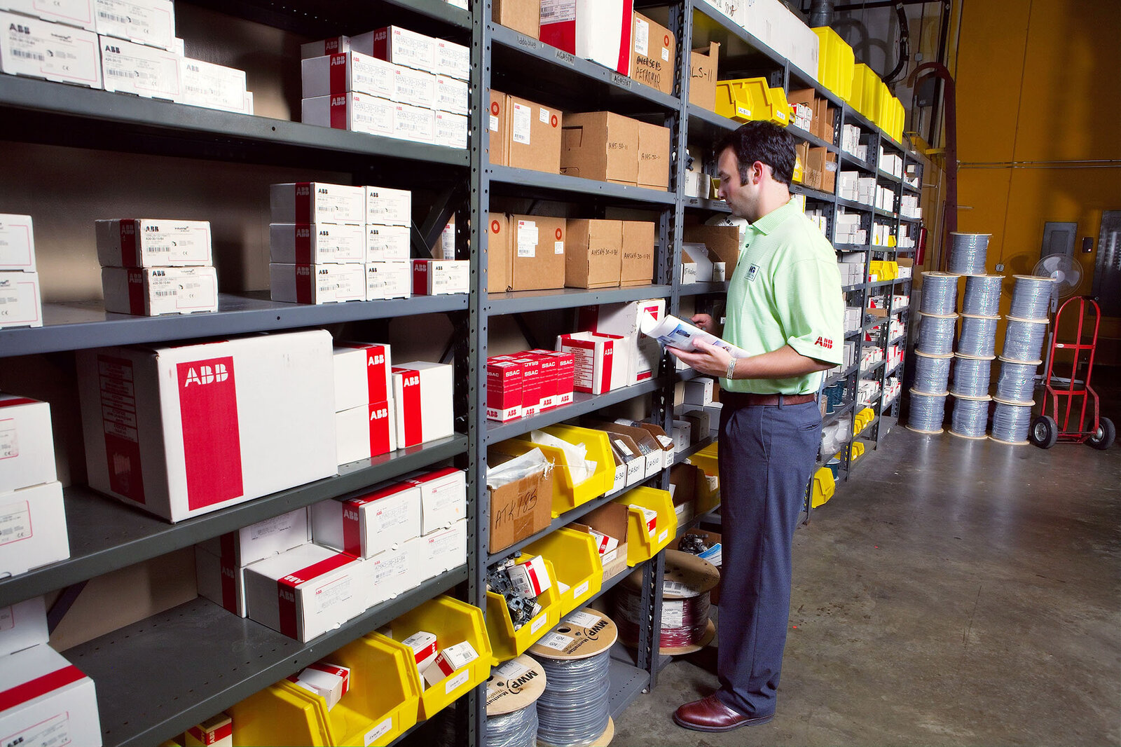 Worker stocking shelves at industrial warehouse