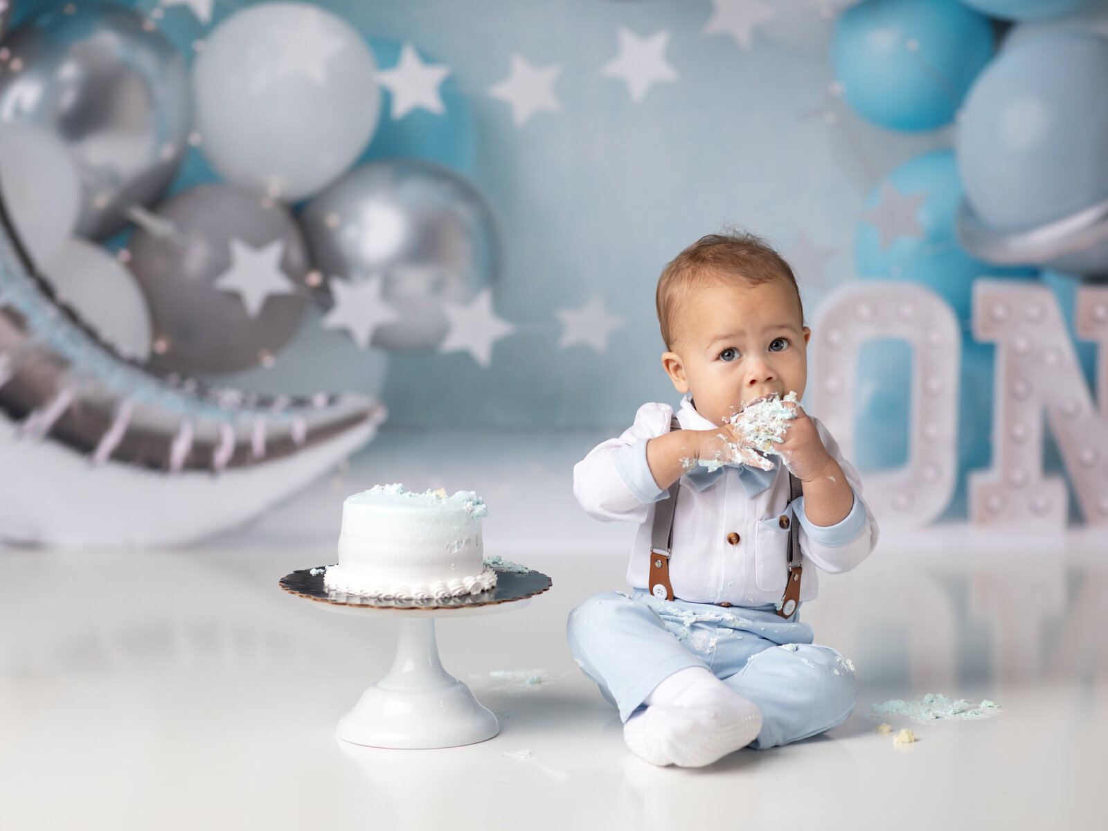 one year old boy eating cake for cake smash photoshoot