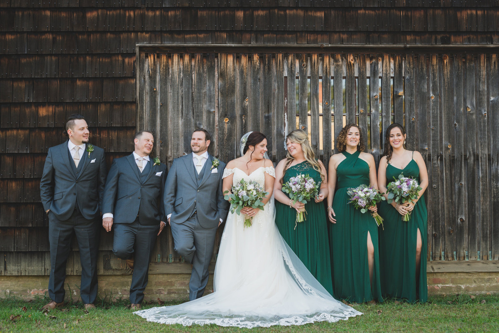 bridal party posing in front of barn at The Barn at Old Bethpage
