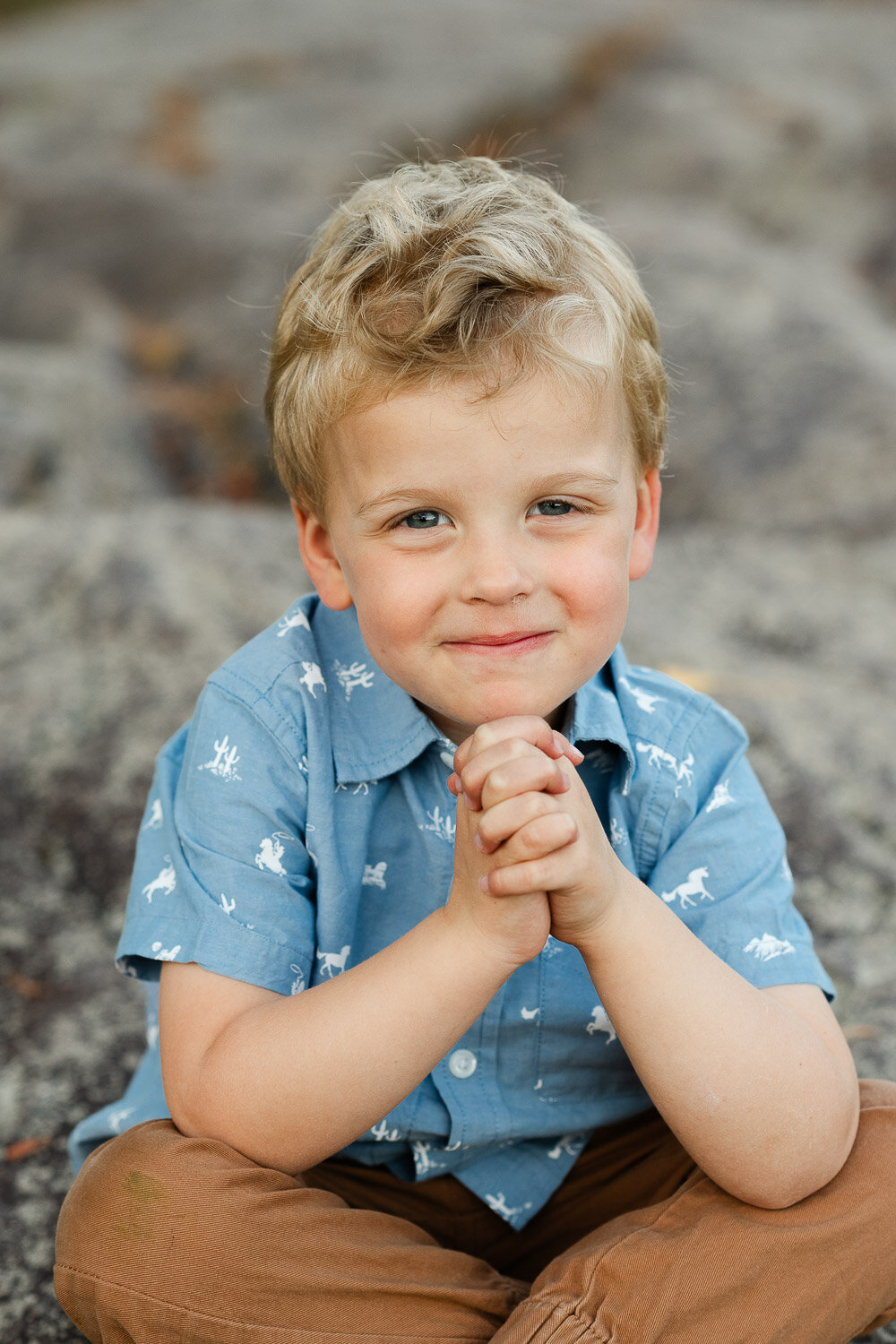 toddler boy sit with hands under chin