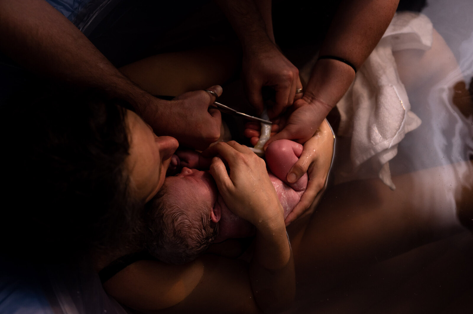 parents cut umbilical cord after waterbirth