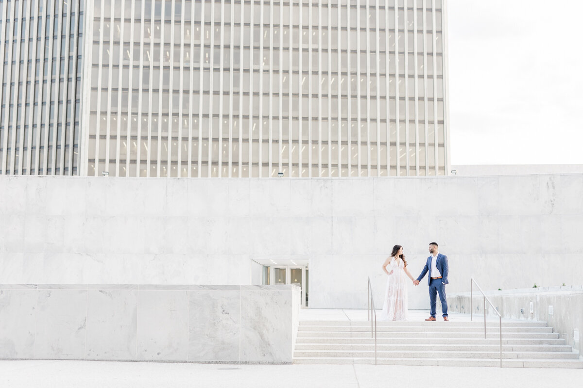 Couple holding hands on the steps at Empire Plaza in Albany, NY.