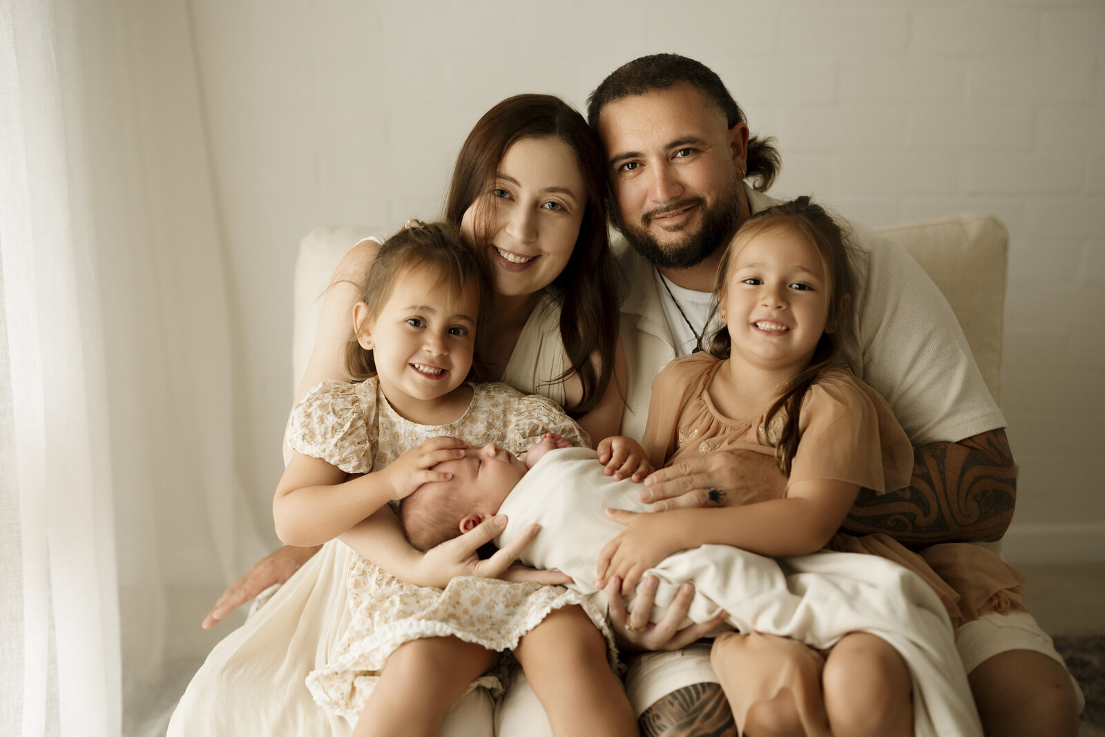 Newborn and parents studio photoshoot in Perth, featuring a timeless and loving embrace of a family with their newborn.