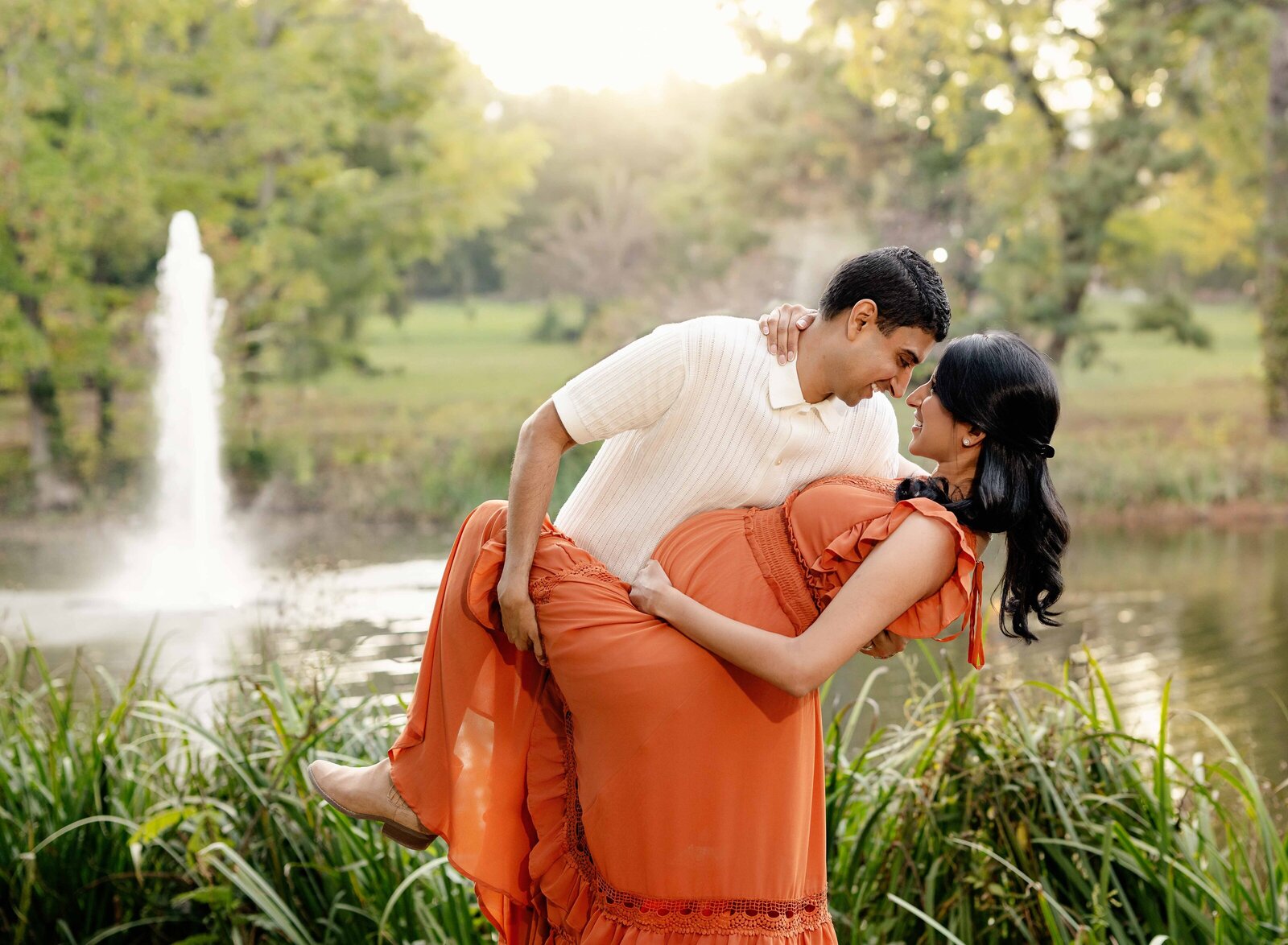Dad dipping pregnant wife back while taking outdoor maternity photos near Atlanta.