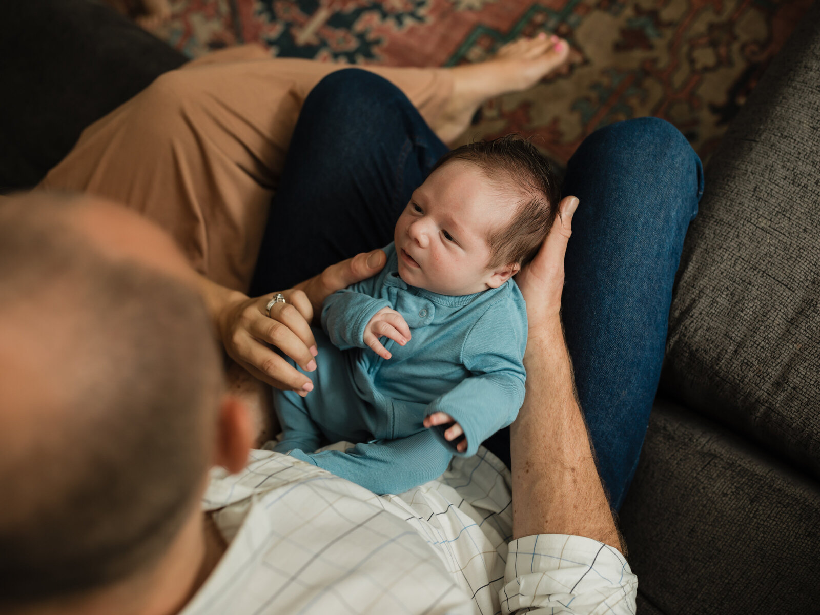 mom and dad holding newborn baby boy for in home lifestyle session 