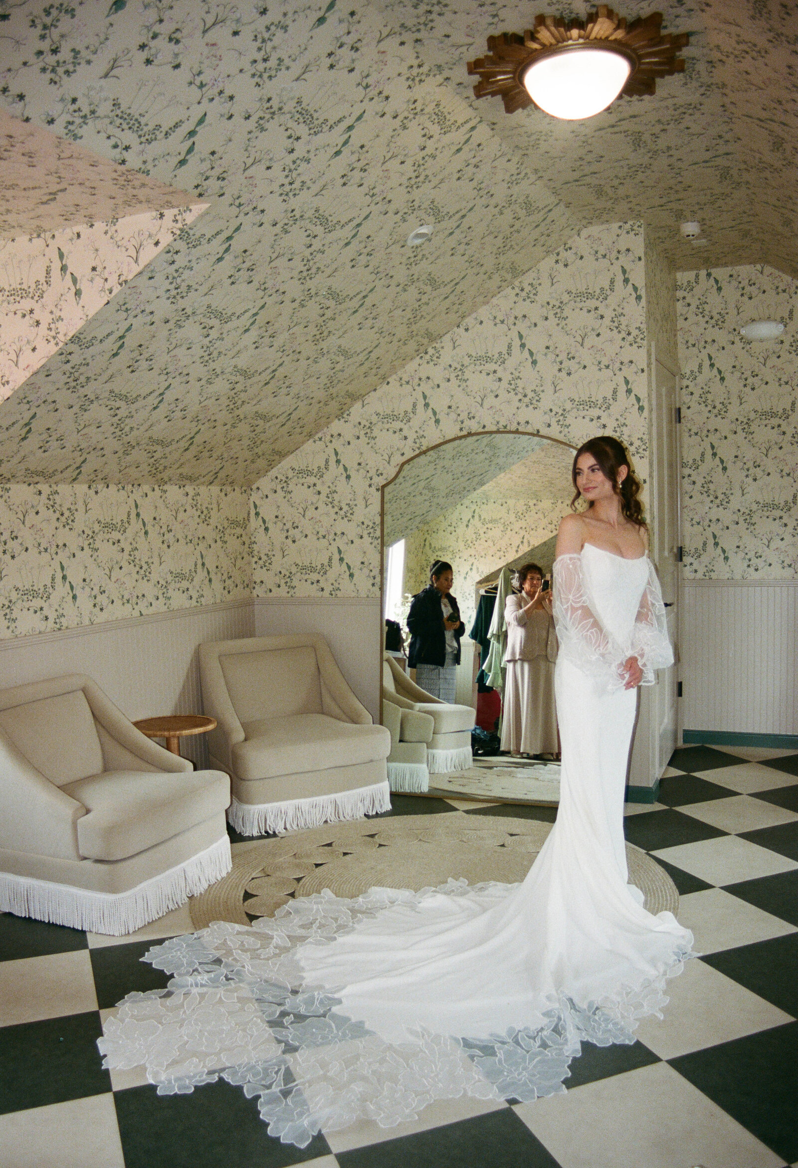 The bride is trying on her wedding dress with her mom