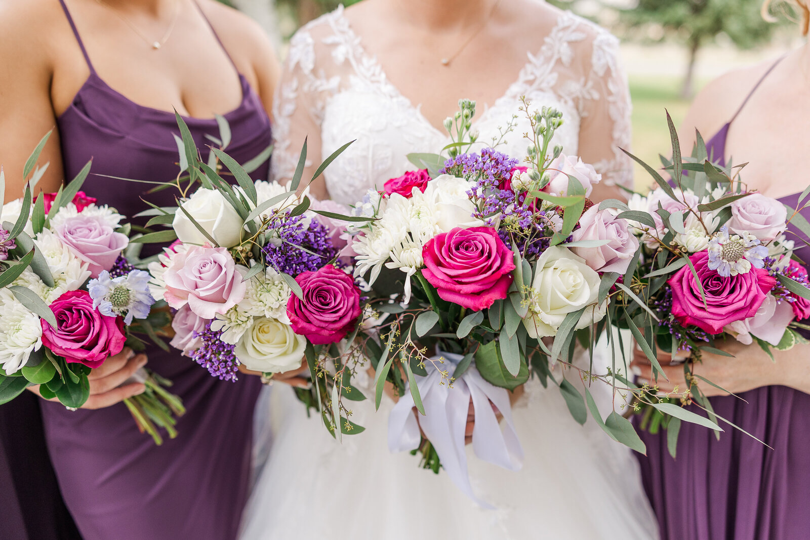 Bridesmaids holding pink, purple, and white floral bouquets at a Ridgway State Park wedding, adding a romantic pop of color