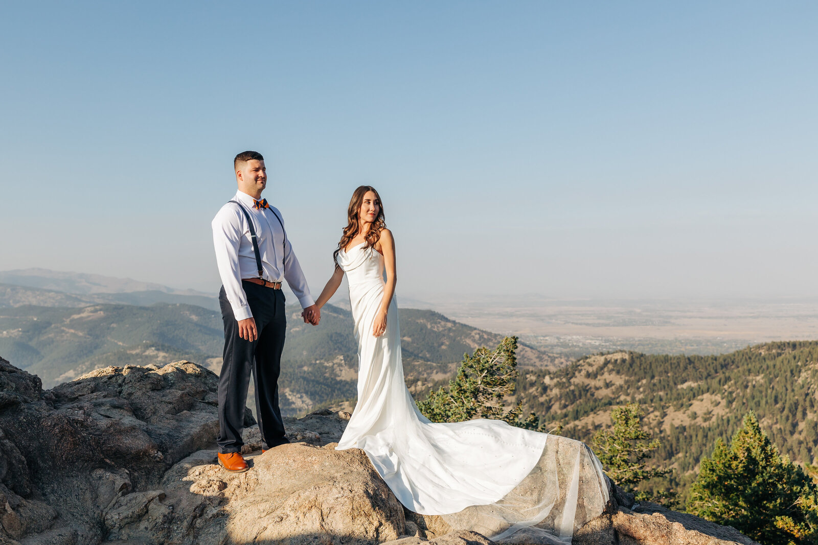 Denver Wedding Photographer captures bride and groom holding hands on rock