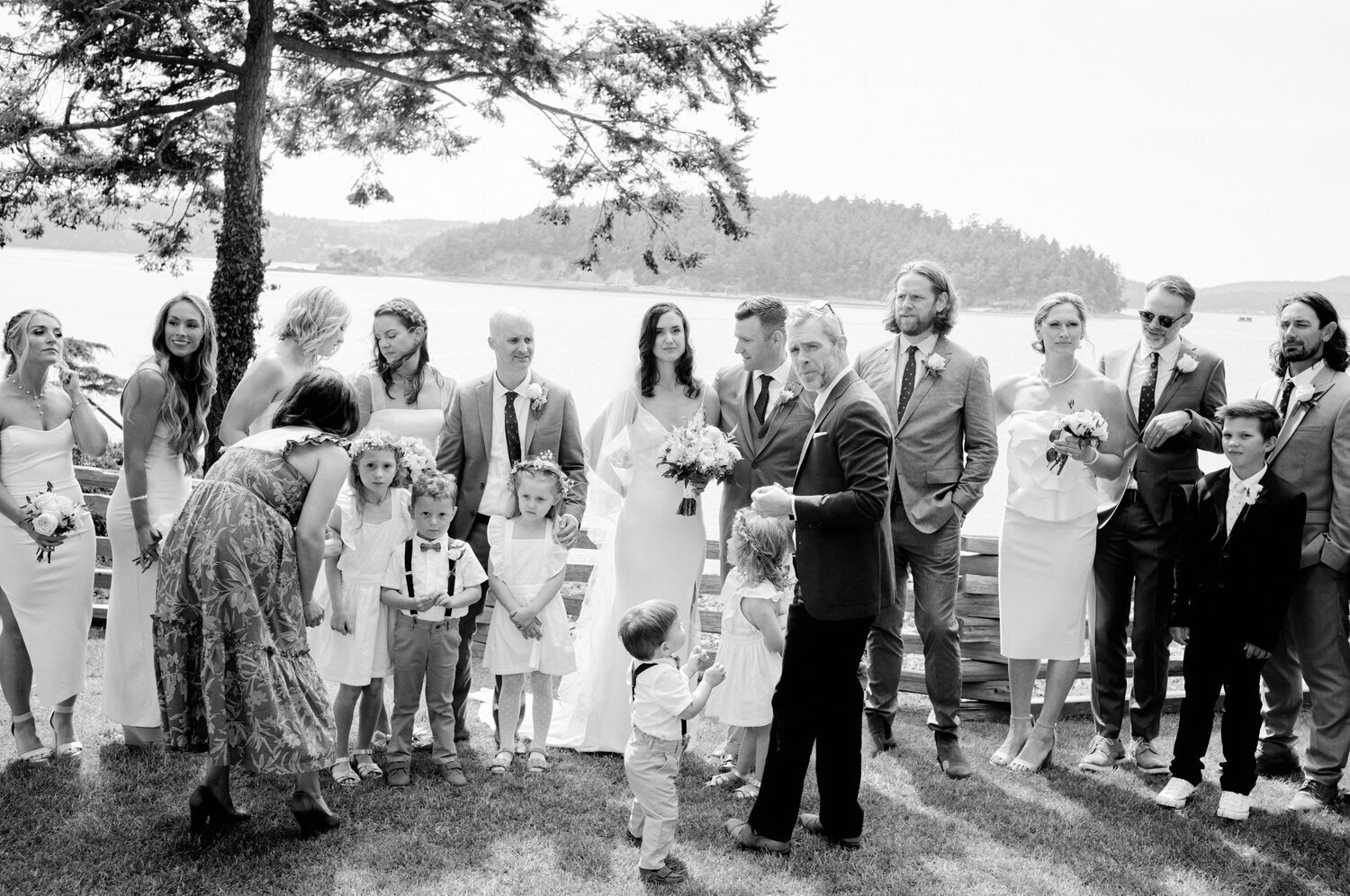 Chaotic scene of the wedding party arranging themselves for the family portrait