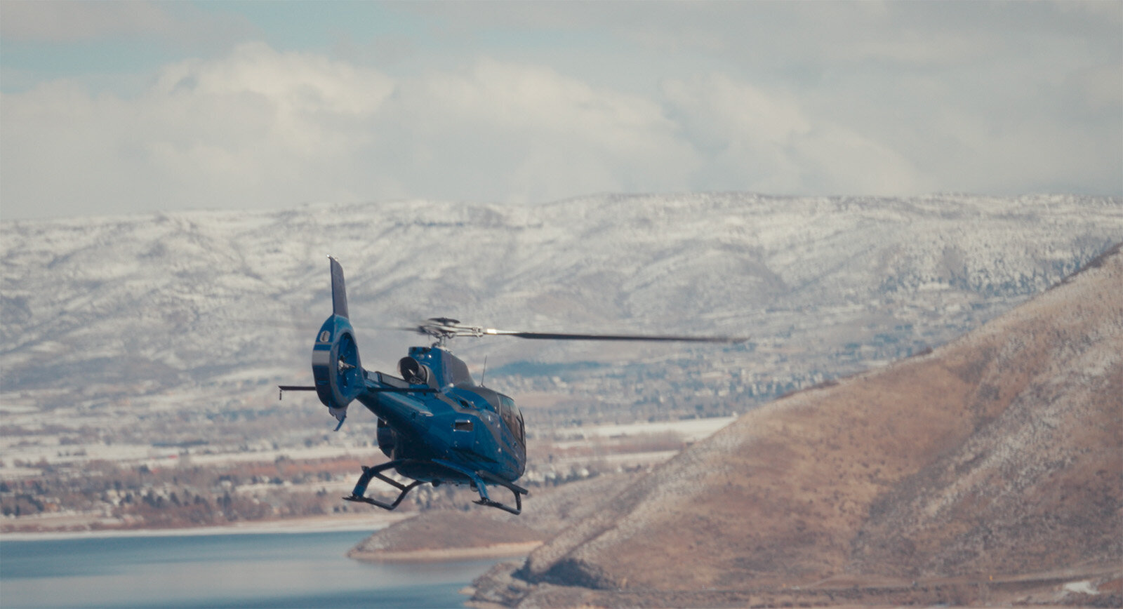 Blue helicopter flying over blue lake tahoe scenic tour