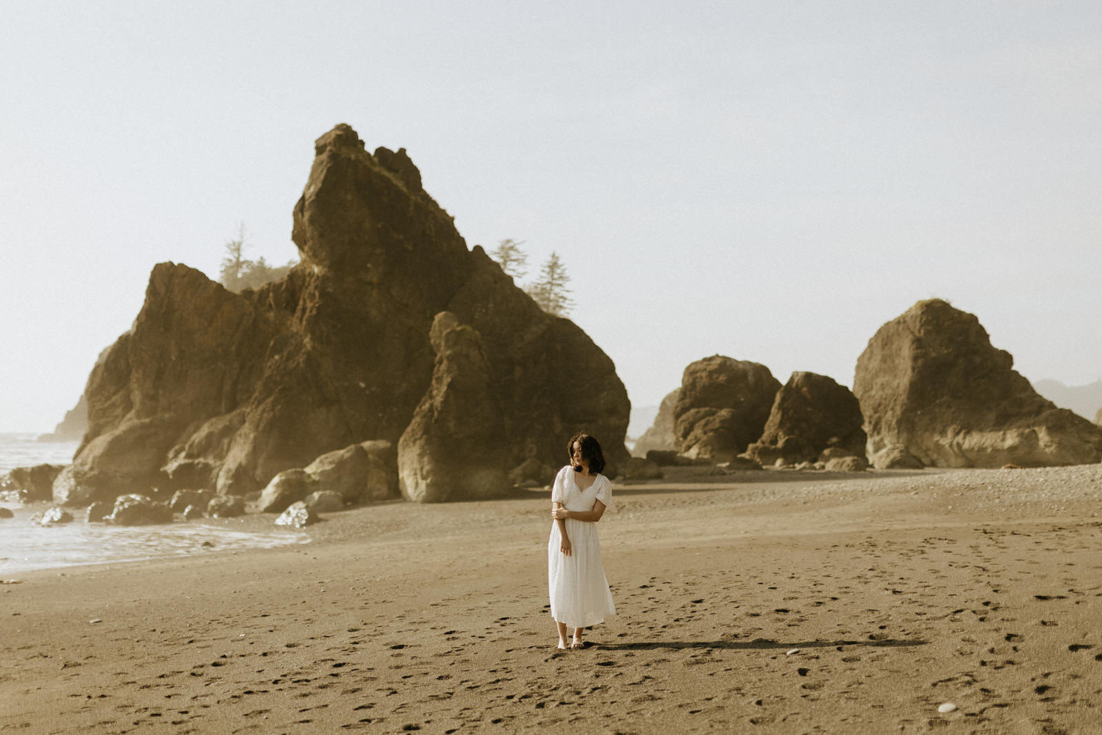A senior girl standing in front of beautiful sea stacks at Ruby Beach in Olympic National Park.