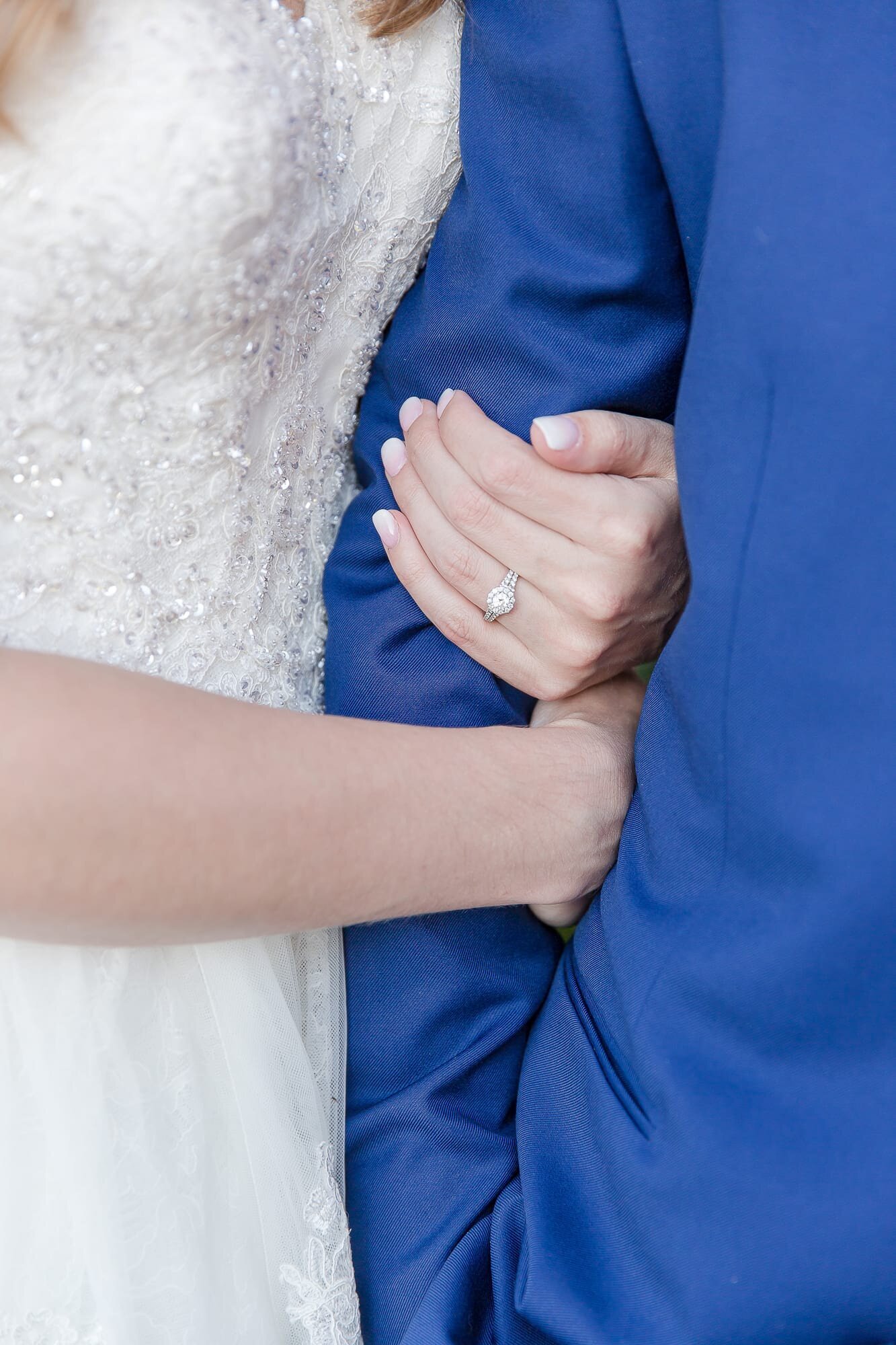 bride-holding-grooms-arm-with-blue-suit