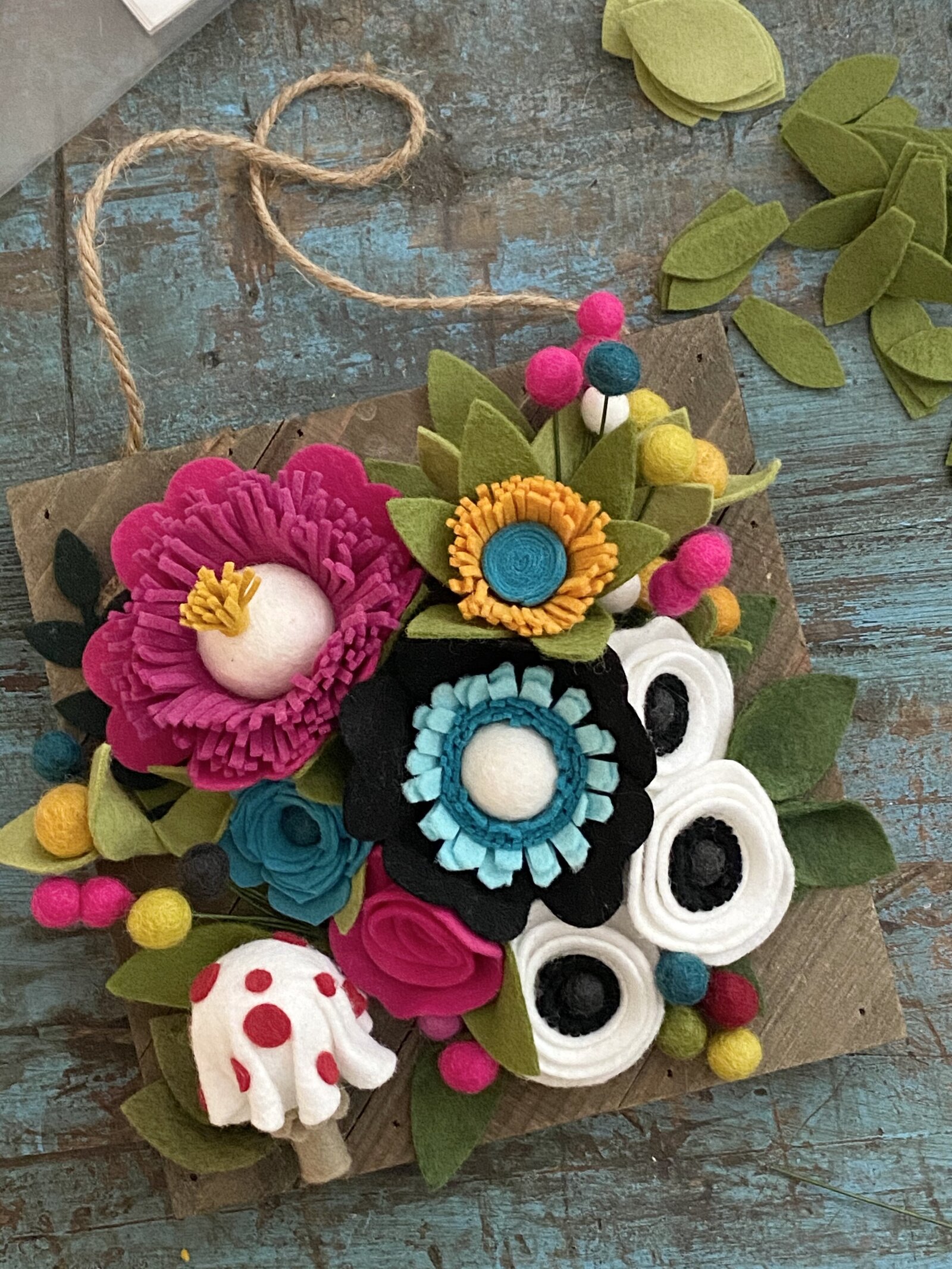Handmade felt flower picture with felt mushroom.