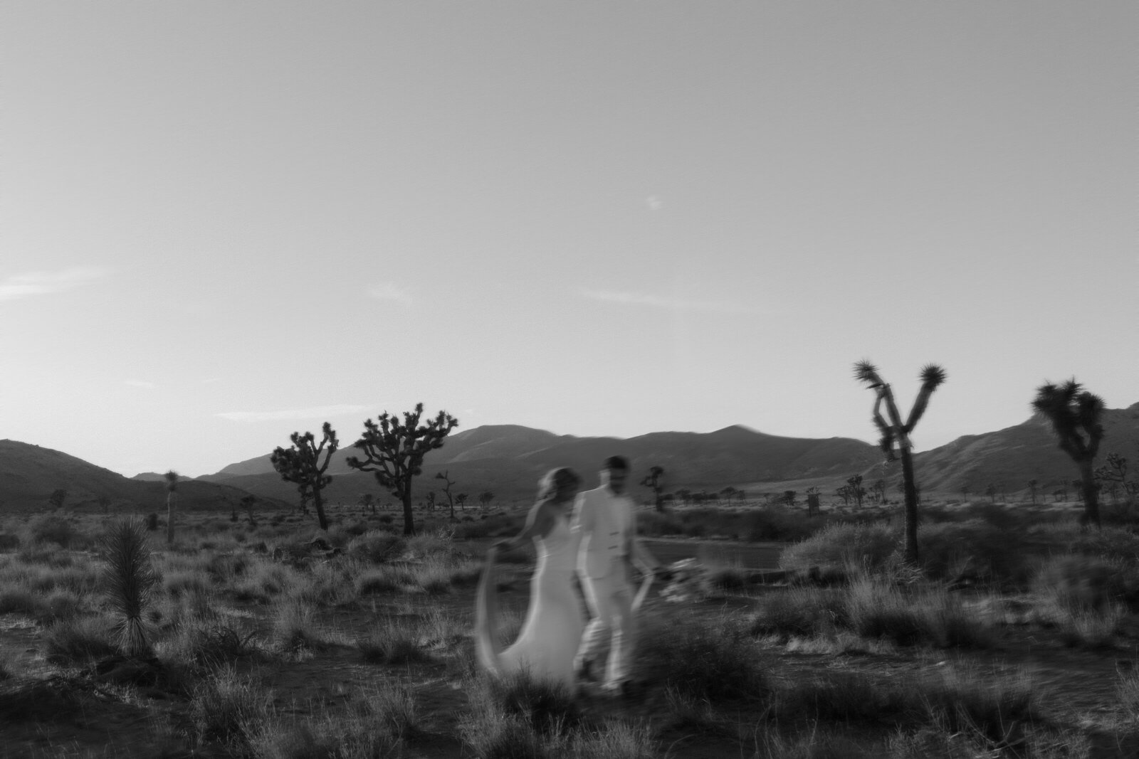 Bride and groom running in desert near lake powell