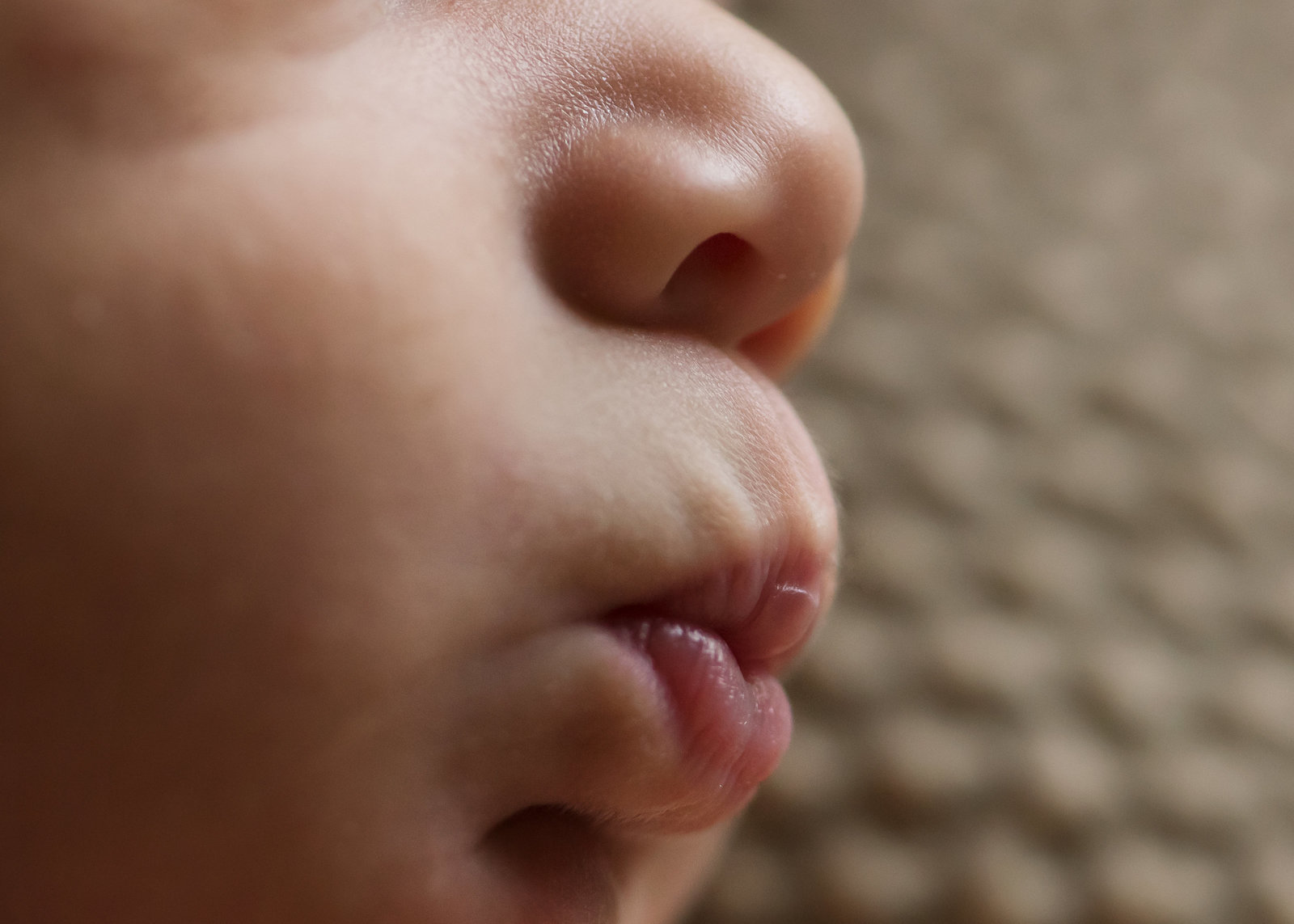 close up photo of newborn baby making kissy lips